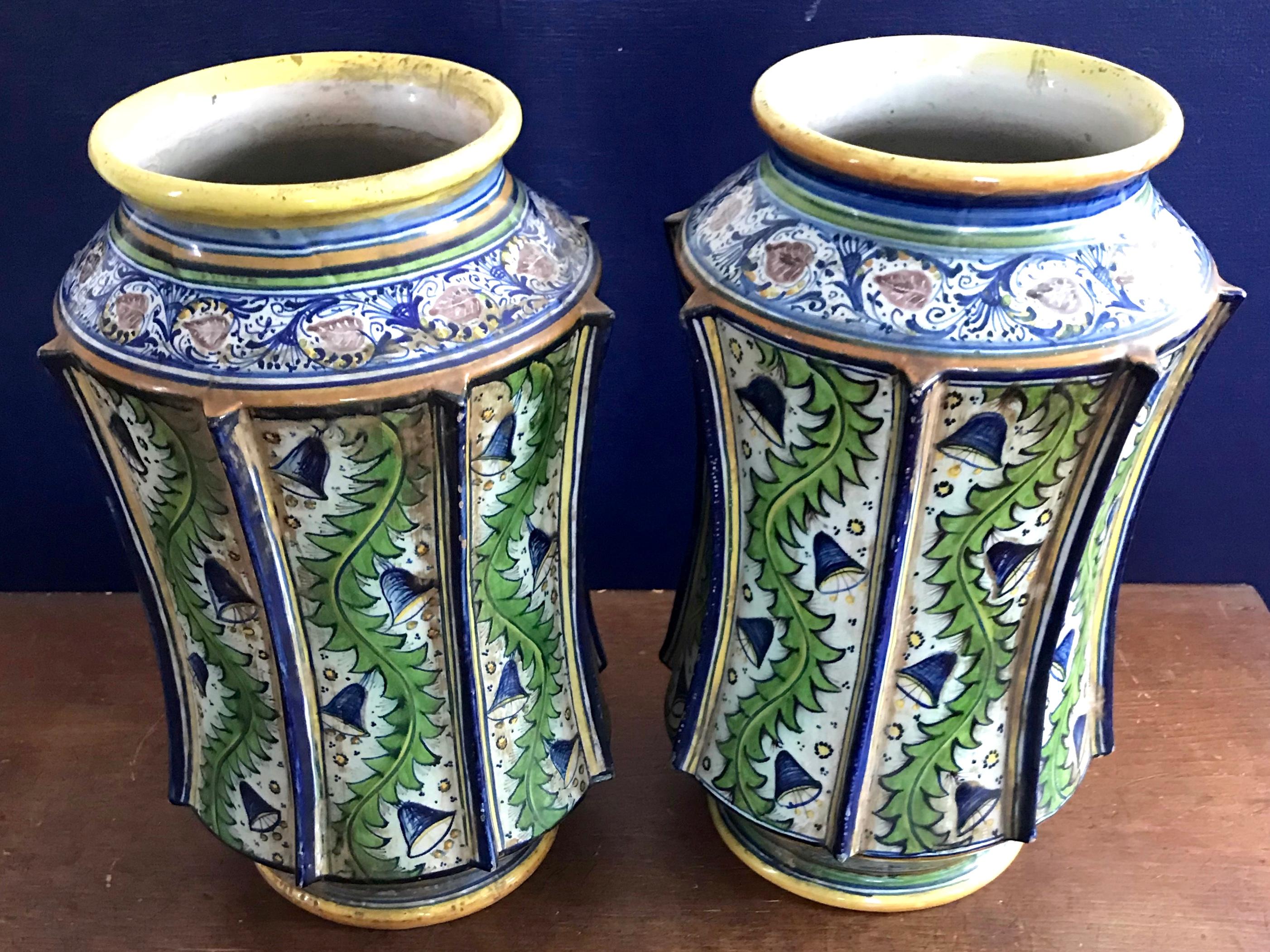 Pair large green and blue majolica apothecary jar vases. Italian cylindrical ribbed and slightly concave tin glaze earthenware jars by the famed Cantagalli factory. With blue bell shaped flowers on green leafy garlands; yellow banded accents at rim