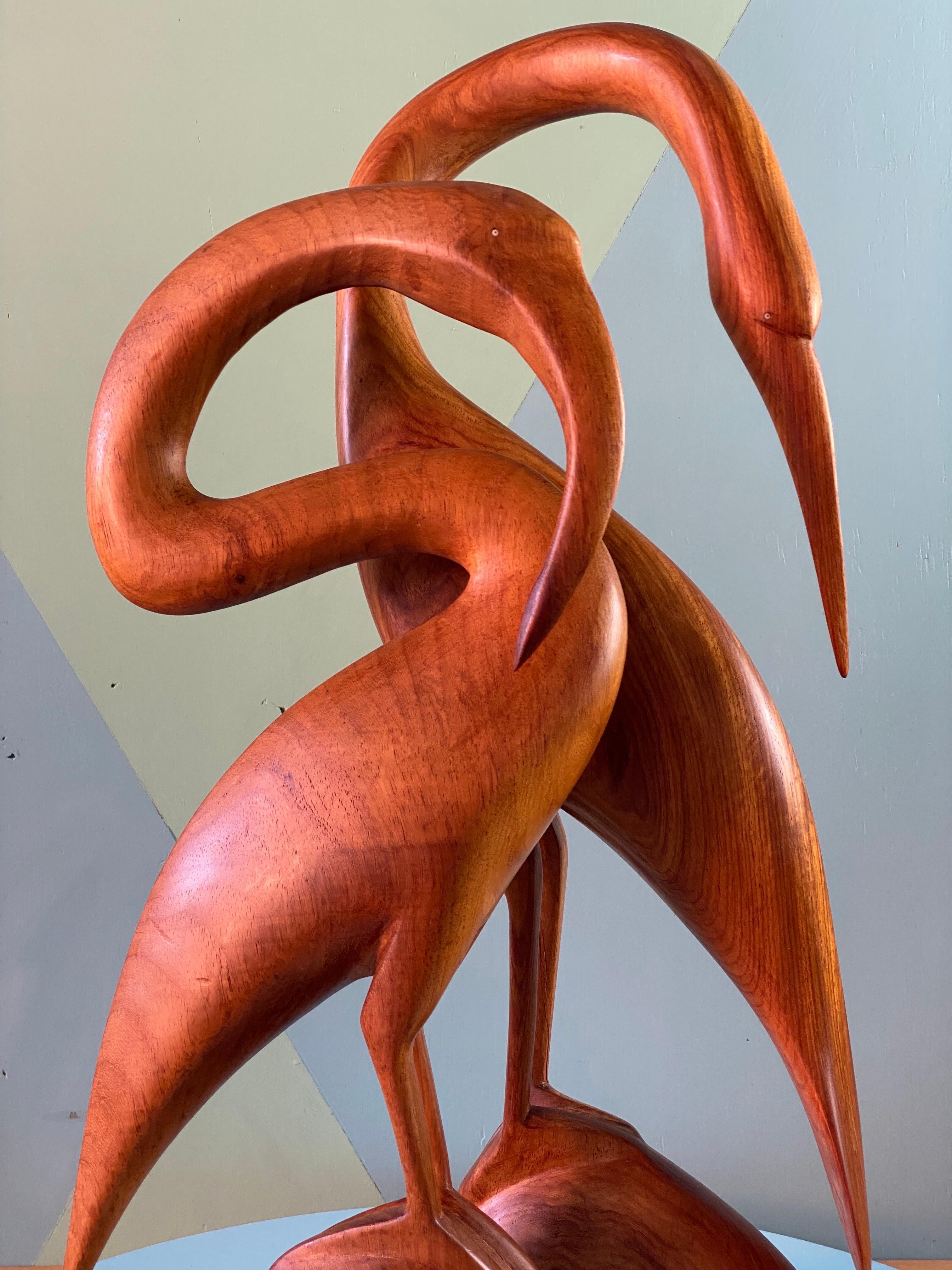 A pair of hand carved teak Heron, dating to the late 1960s, perhaps early 1970s. 

There are no makers marks, signatures or labels. Balinese or Sumatran, indicated by the teak wood, sinuous style and carving skill required for this level of