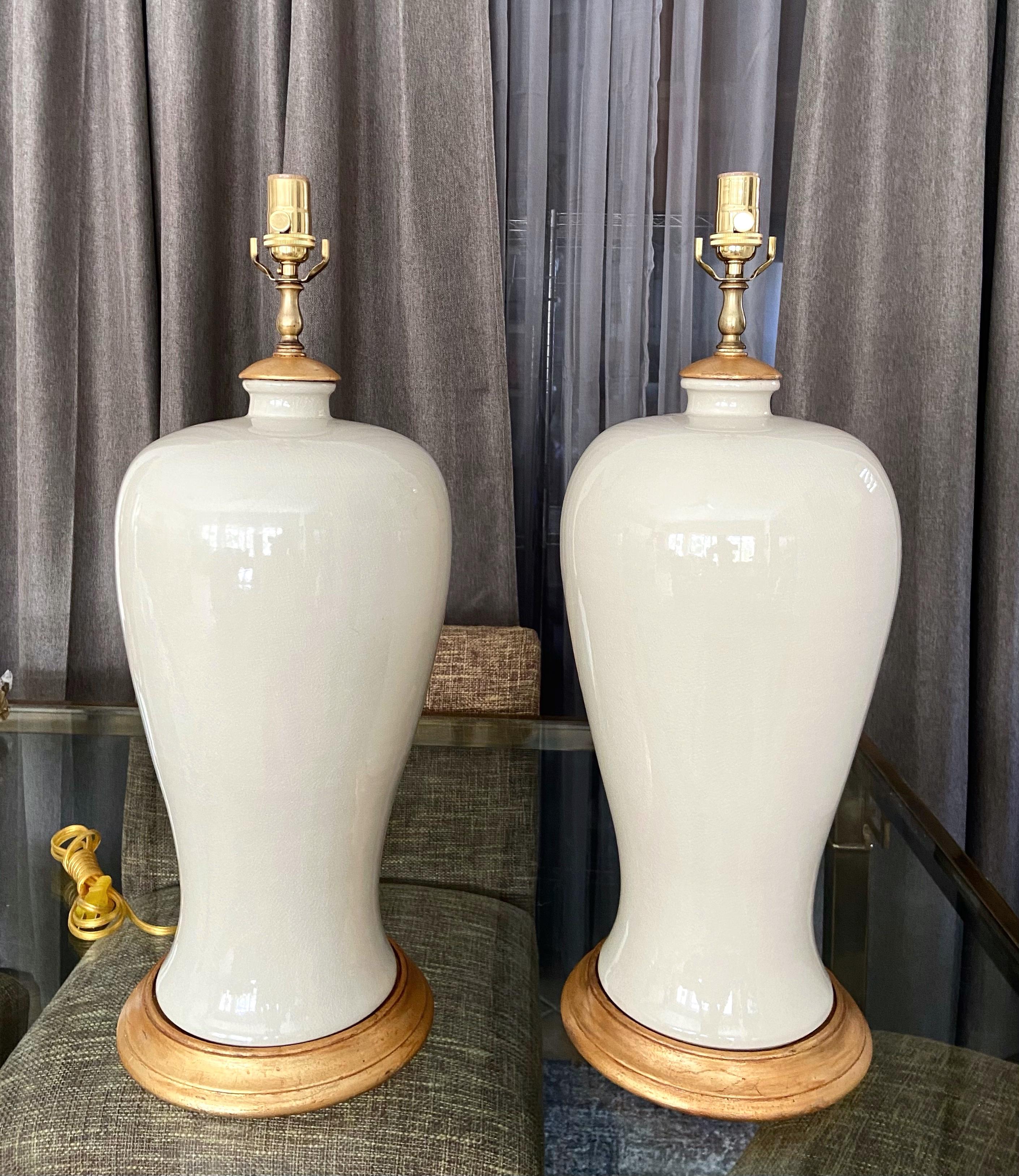 Pair of large Japanese Asian blanc de shine monochrome plume shaped porcelain vase table lamps. Mounted on turned giltwood bases with matching v-caps. The color of the porcelain is a rich creamy white with tinge of green depending on light source.