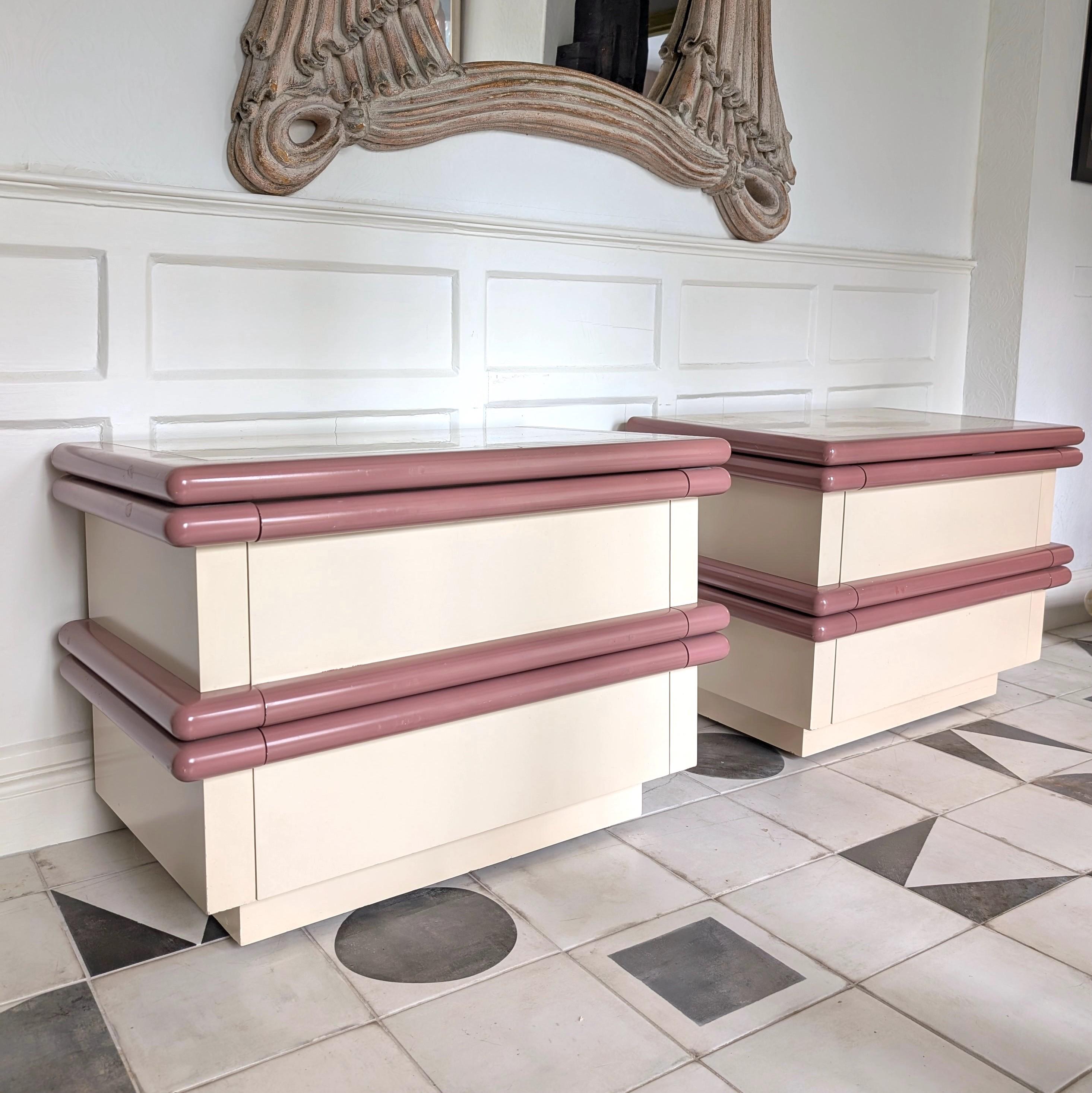 Pair of large Jay Spectre style postmodern travertine top bedside cabinets, USA 1980s. Mauve lacquer bullnose details, ivory coloured laminate, inset travertine tops.
Each has two large wood-lined drawers, which run smoothly
A teeny bit of