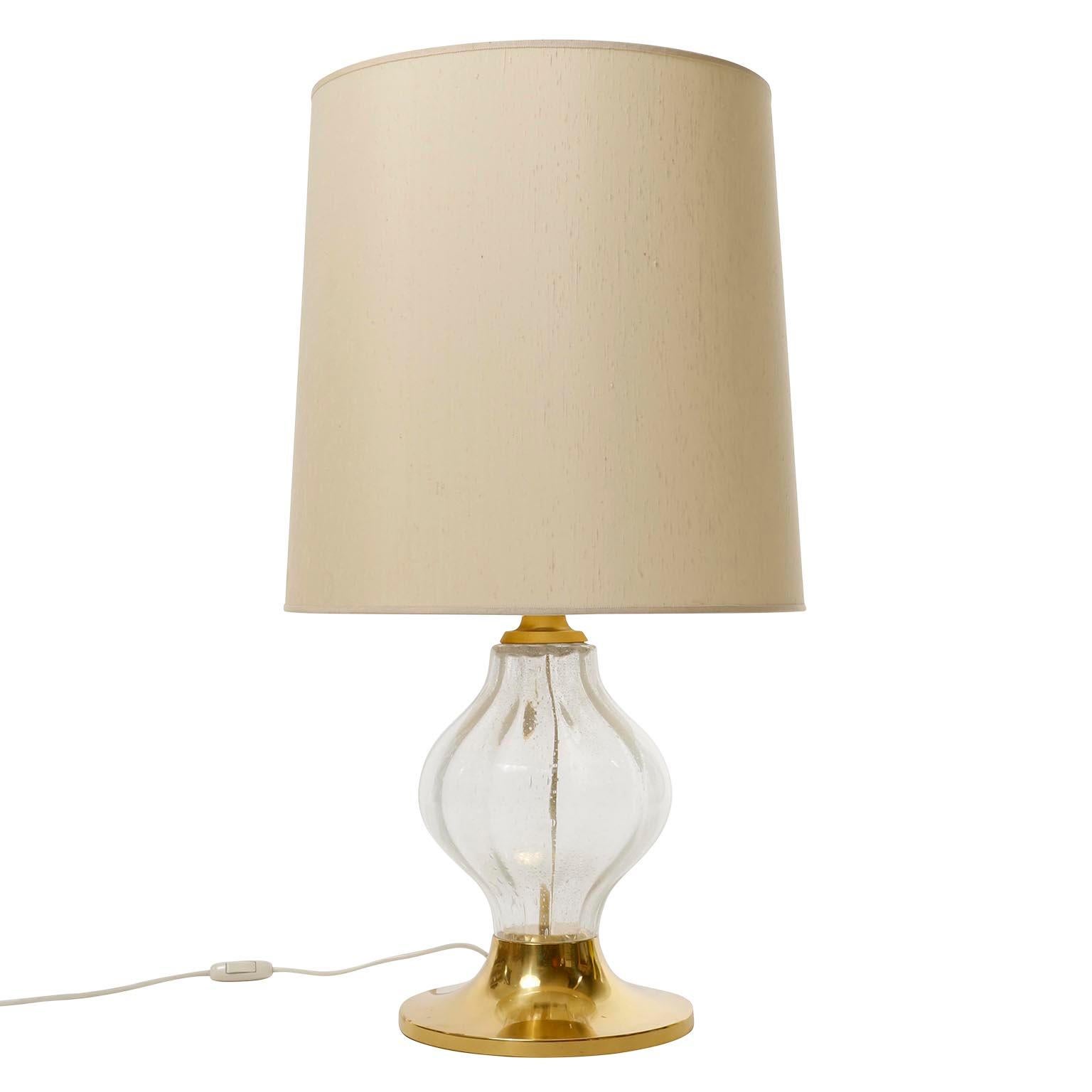 A pair of rare and large 'Tulipan' table lamps by Kalmar, Austria, manufactured in midcentury, circa 1970 (late 1960s or early 1970s).
A polished brass base with a large hand blown and tulip shaped seeded or bubbled glass body. Each light has one