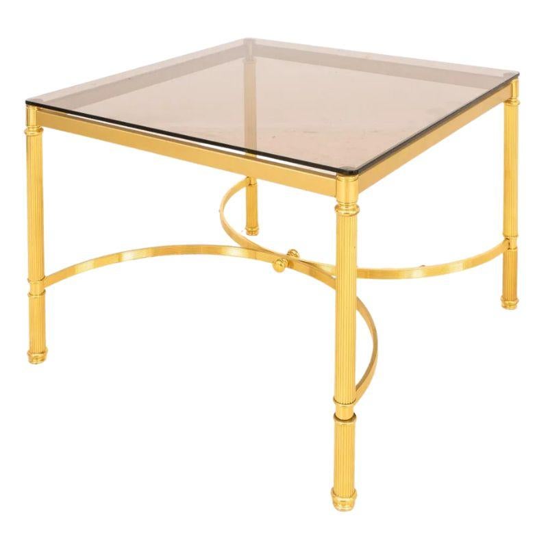 Pair of large Maison Jansen style smoked glass and gilt metal square side tables. The four legs are cylindrical and fluted with neoclassical details. The curved X base is also fluted and meets in center with a round finial detail on two sides. An