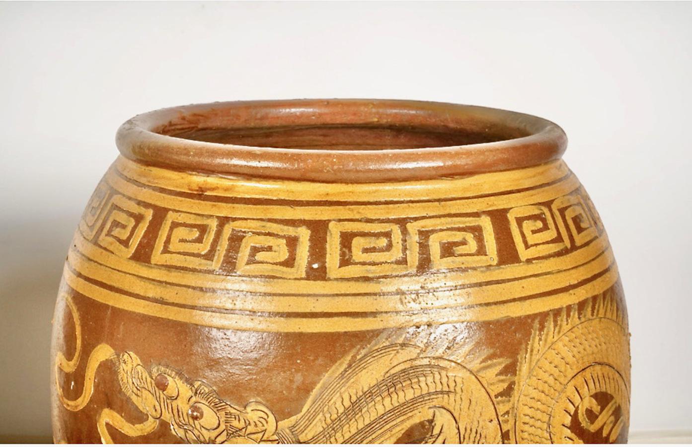 This is a great pair of large late 19th/early 20th century Martaban storage jars. The jars are decorated with flaming dragons with Greek Key borders. Both of these jars are in very good condition with anticipated patination, but undamaged. Martaban