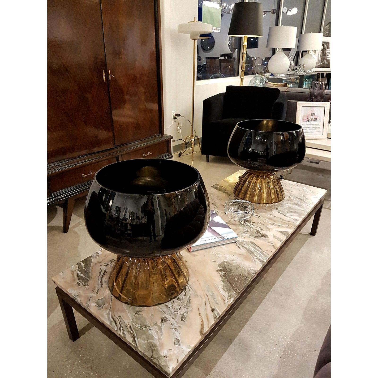 Pair of large Mid-Century Modern Murano glass table lamps with black almost opaque tops and brown transparent bases.
Attributed to Cenedese, Italy, late 1960s
The pair of vintage table lamps have brass fittings.
When lit, a halo of light comes
