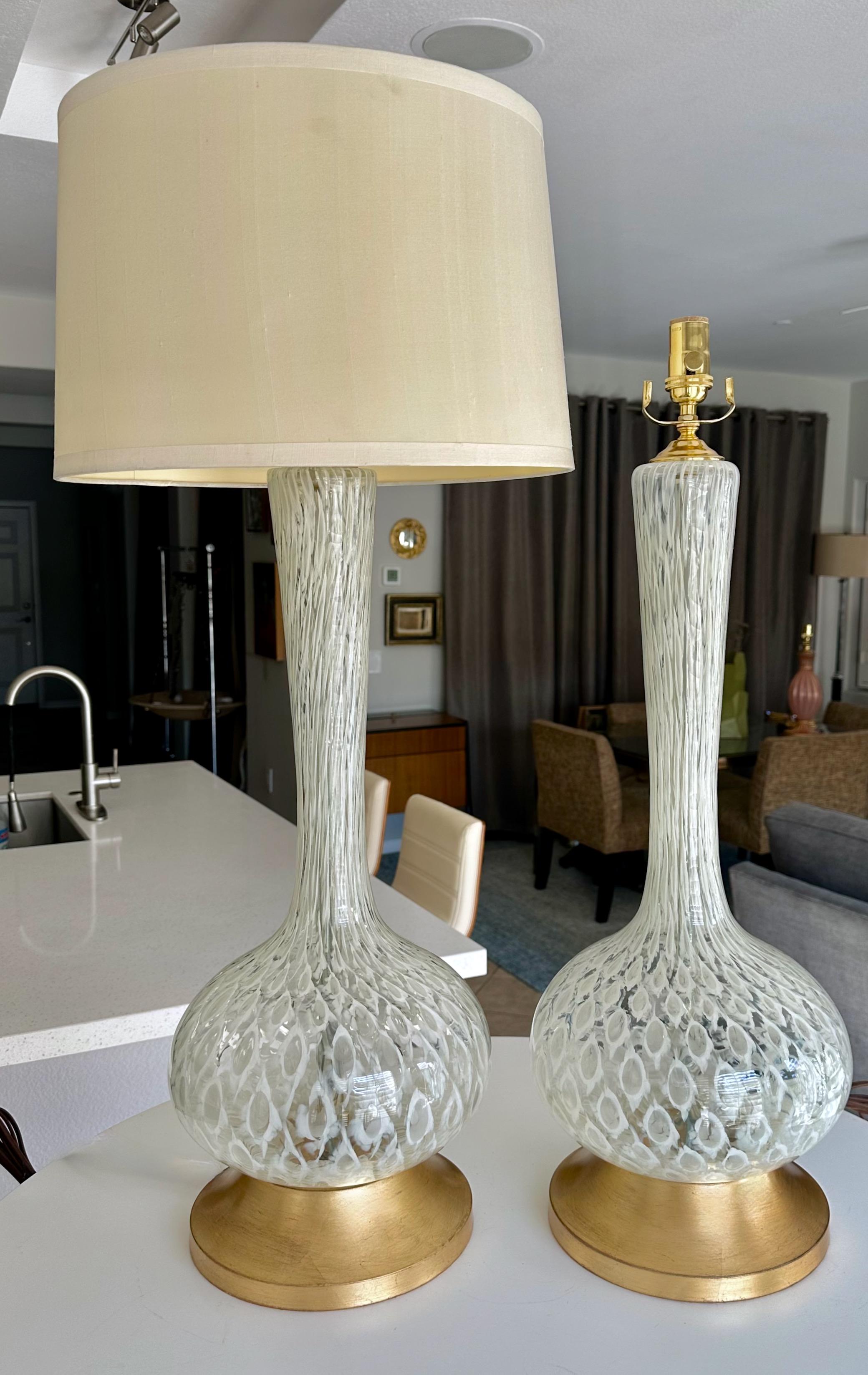 Coppia di lampade da tavolo a collo lungo in vetro soffiato a mano di Murano su basi in metallo dorato. Il design del bicchiere è realizzato con un esclusivo motivo a bolle di controllo bianche e chiare. Cablata di recente con prese a 3 vie in