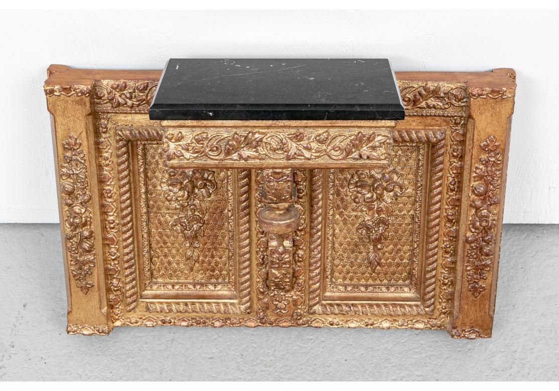 An interesting and unusual pair of large angular brackets with center projecting shelf sections with beveled black marble tops. The whole bracket is decorated with bands of grape vines, and floral sprays in relief on the sides and inner recessed