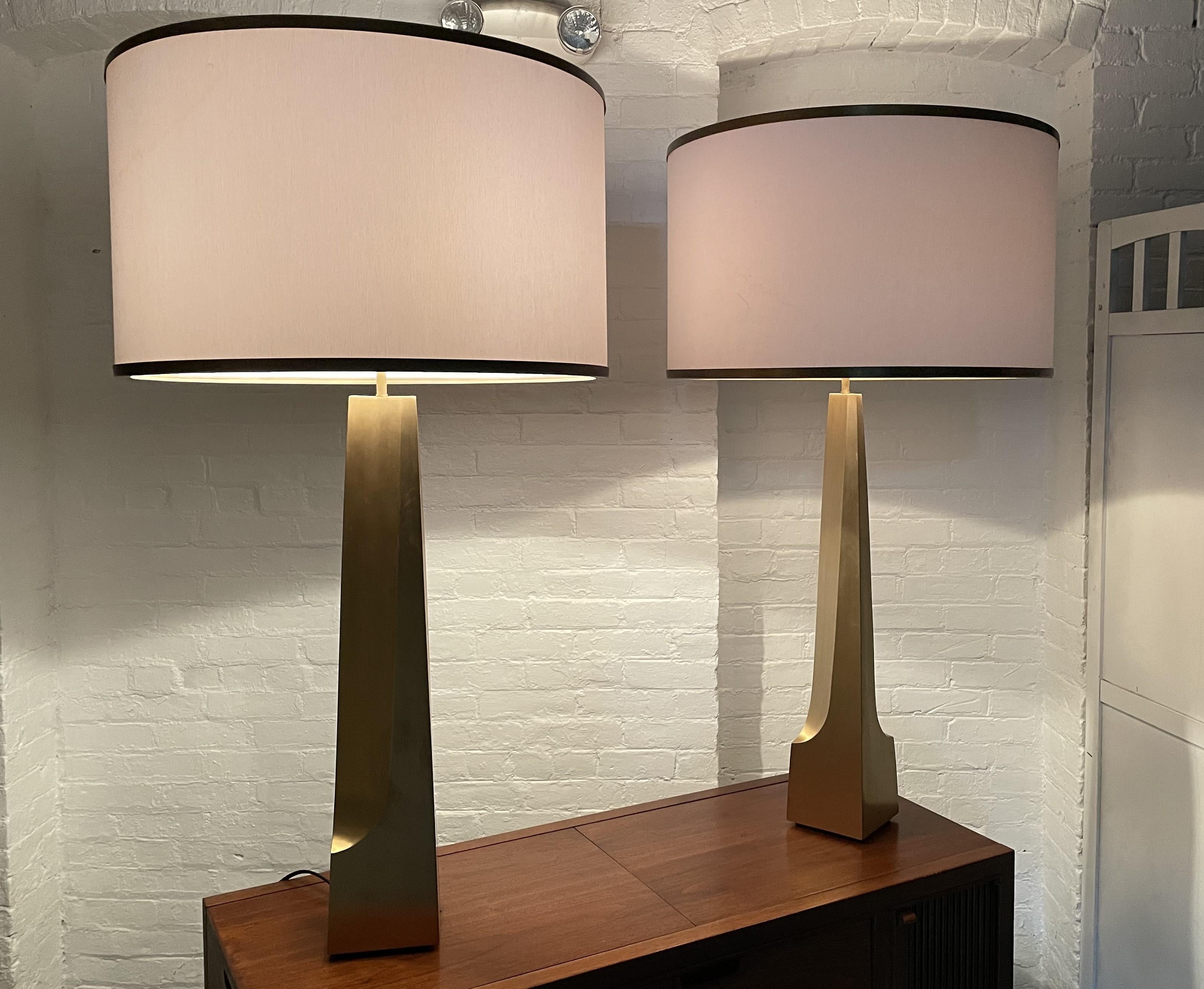 Pair of large solid bronze sculptural lamps. The shades have bronze trim.
Measures: 45.75H. Base: 5.25W x 5.25D.
Shades measures: 24 in diameter x 14.5 height.