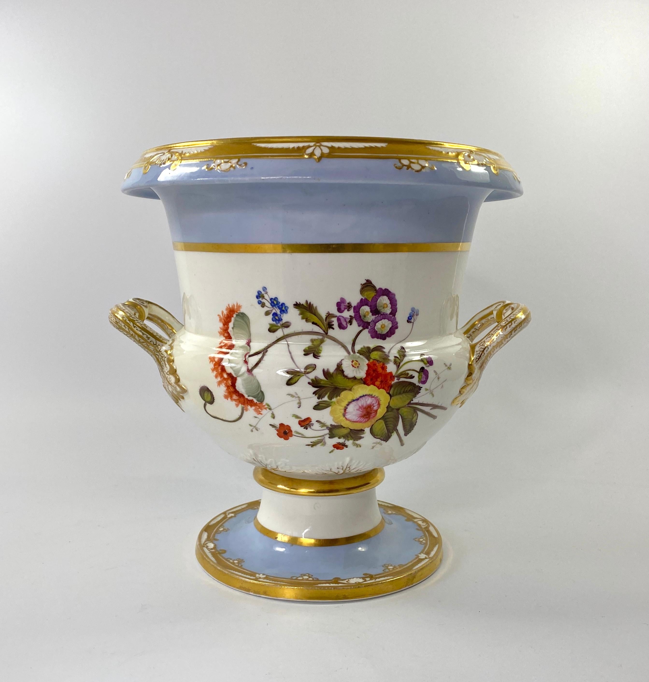 Pair of large Spode porcelain ice pails, c. 1820. The campana shaped vases, painted with large sprays of flowers, between lavender borders. Having elaborate twin branch handles, terminating in leaves, and heightened in gilt.
Both pails lack their