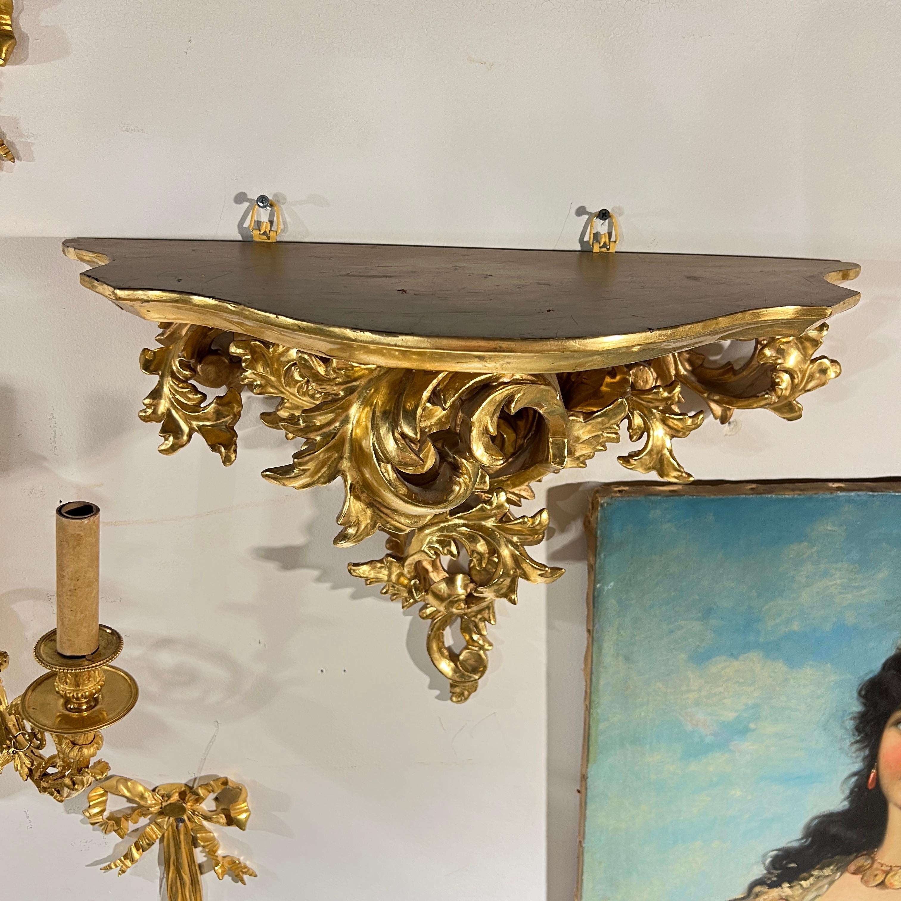 Paar prächtige, große vergoldete und handgeschnitzte Wandkonsolen aus Holz im Barock/Rokoko-Stil  Stil mit aufwendigen und eleganten Blattrollen, misst 22 x 14 1/2 x 10 Zoll und ist in sehr gutem Zustand.