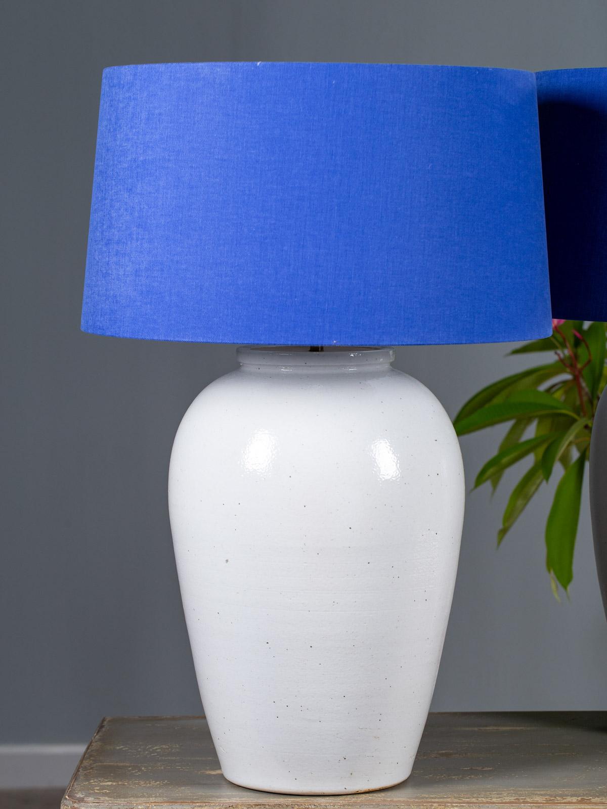 A pair of large handmade glazed white pottery modern lamps with custom delft Blue linen shades. The beautifully simple contemporary profile of these lamps make them suitable for a variety of interior styles. Each lamp was made by hand and then
