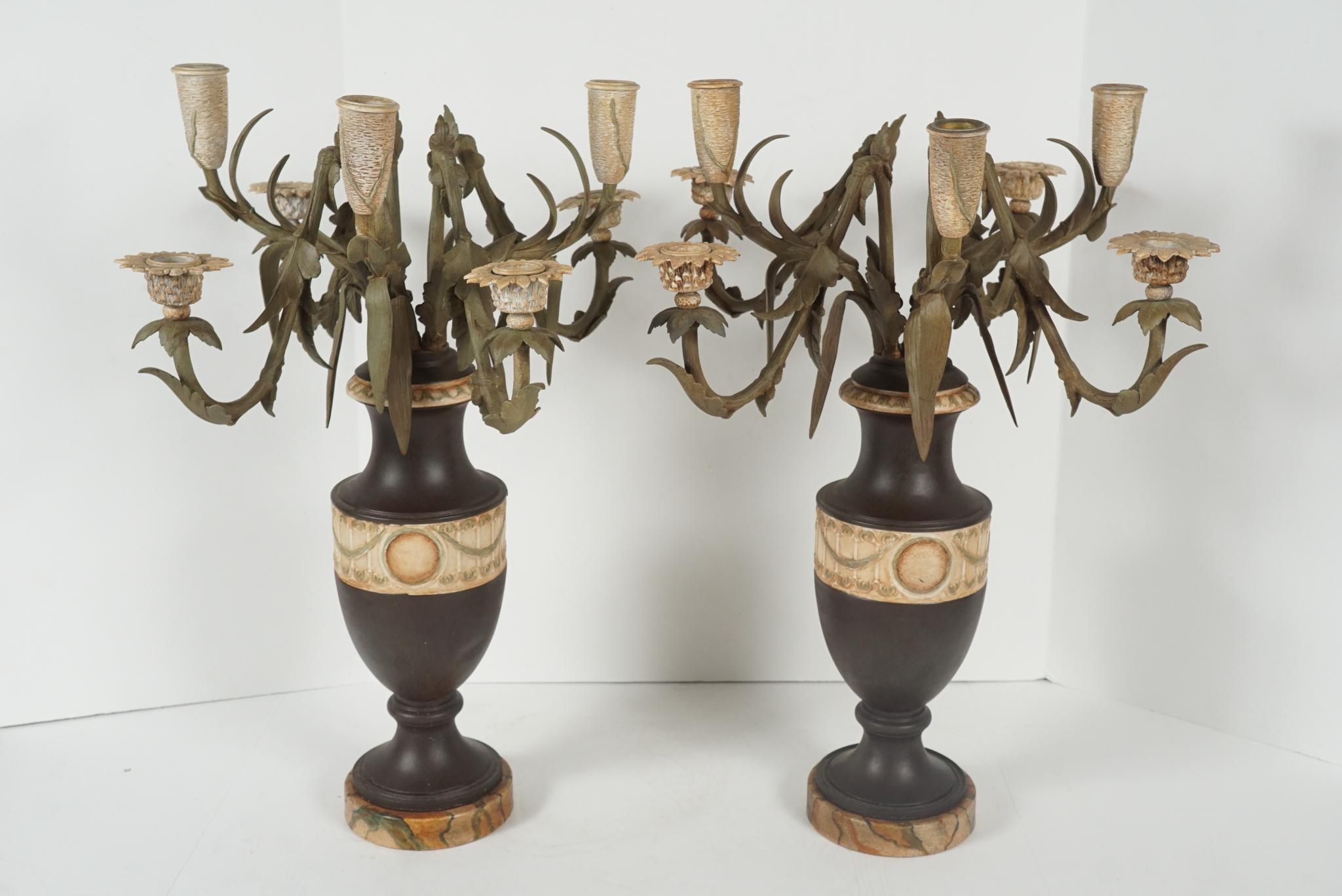 This pair of candelabra made in the form of urns holding floral arrangements are French and were cast in bronze in the 1870s. It’s possible that at one time they were gilded but they now are tole painted and appear to have been so for some time. The