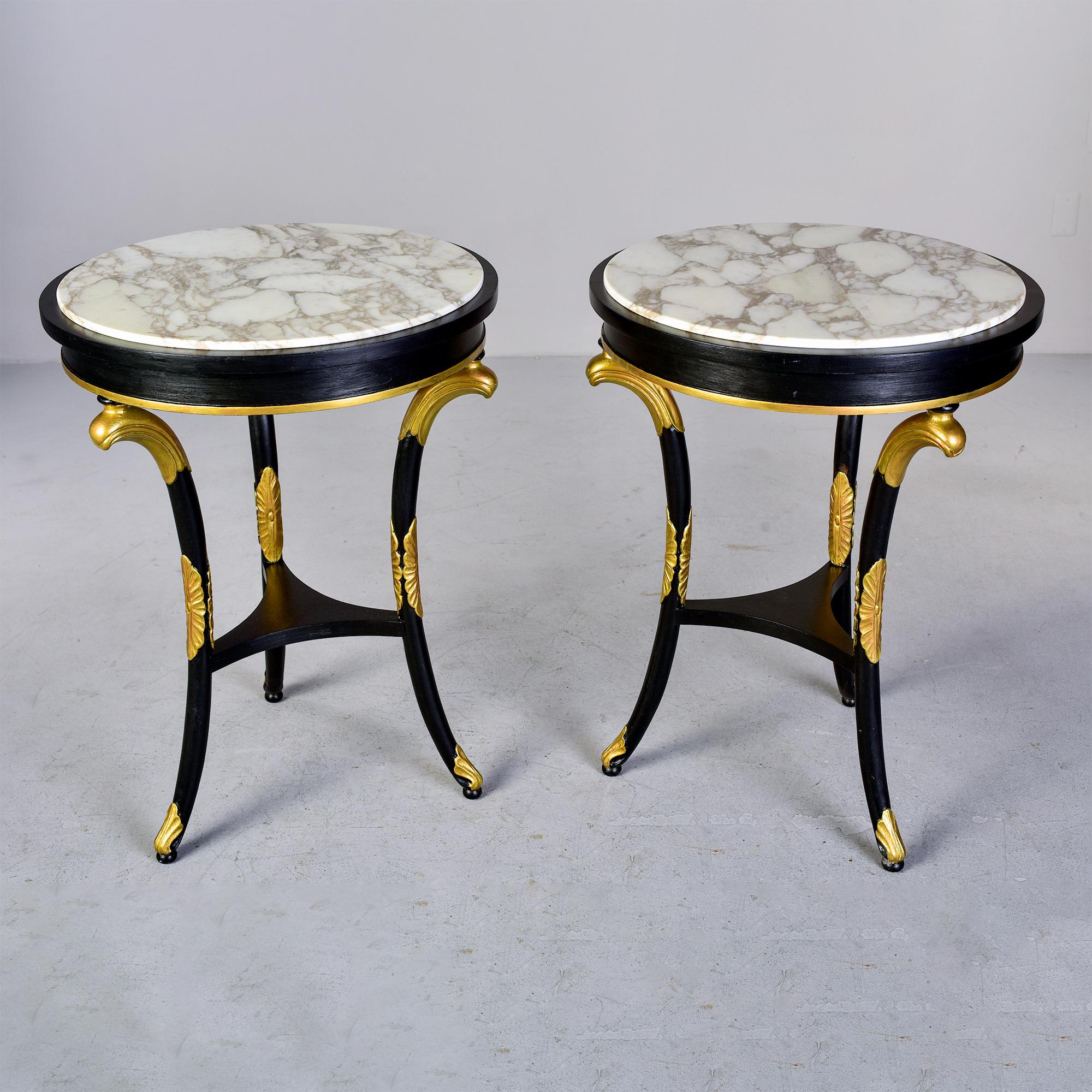 Circa 1880s pair of English side tables feature three legged ebonised base with giltwood fittings and round inset marble tops. Unknown maker. Sold and priced as a pair.