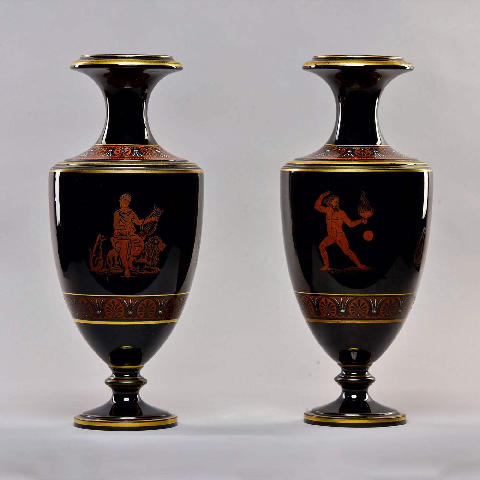 Found in England, this pair of tall black porcelain vases dates from approximately 1880s. Decorated with gilt and classical Greek or Roman figures. Unknown maker. Very good antique condition. Sold and priced as a pair.