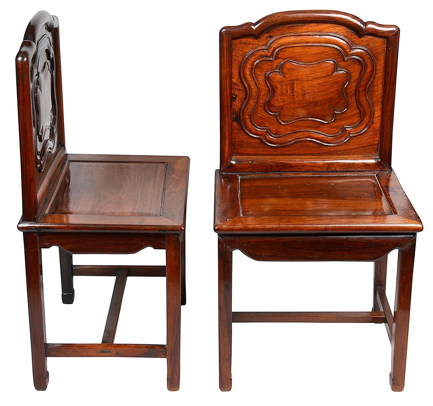 Très bonne paire de chaises d'appoint en bois dur chinois de la fin du XIXe siècle, chacune avec des panneaux sculptés à la main sur le dossier, des sièges à panneaux encastrés, reposant sur des pieds de section carrée, réunis par une entretoise en