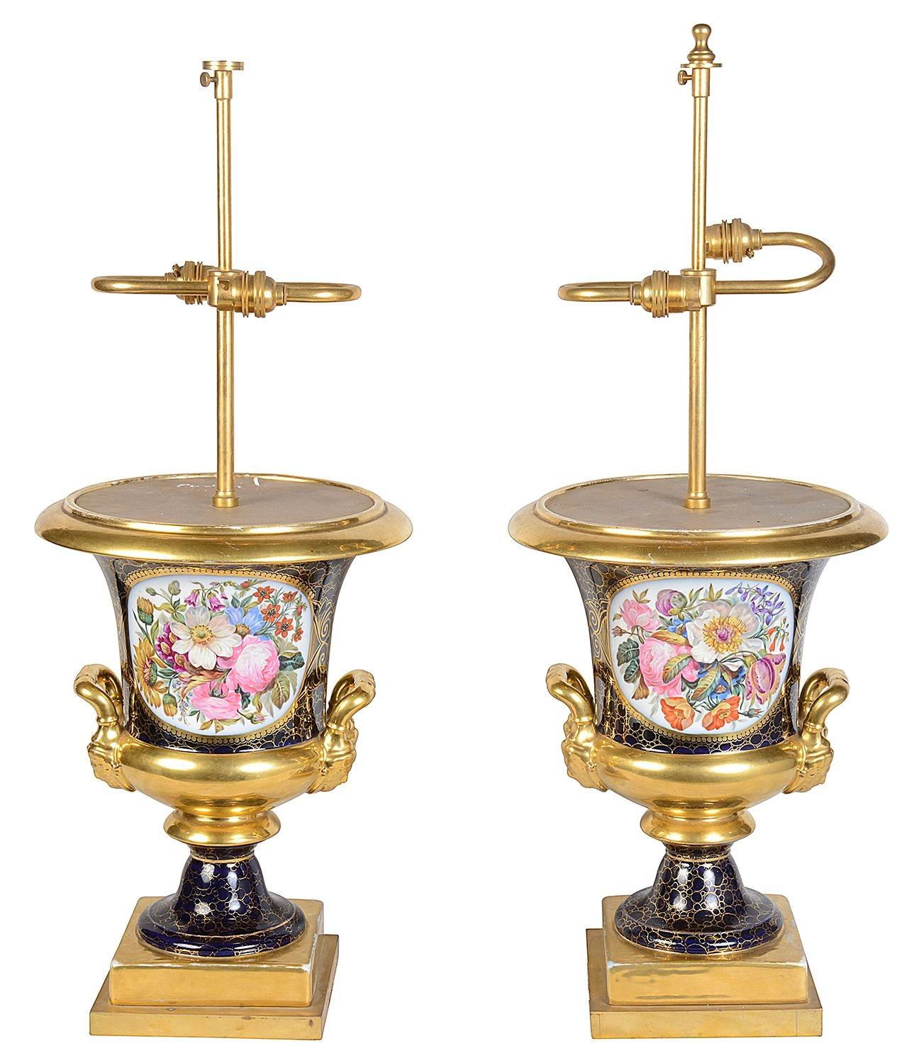 An impressive and decorative pair of French Sevres style porcelain lamps, each with wonderful colourful inset hand painted floral scenes, armoral crests to the reverse. Cobalt blue ground and gilded mouldings and handles.

Batch 78 G204/23 YNKZ