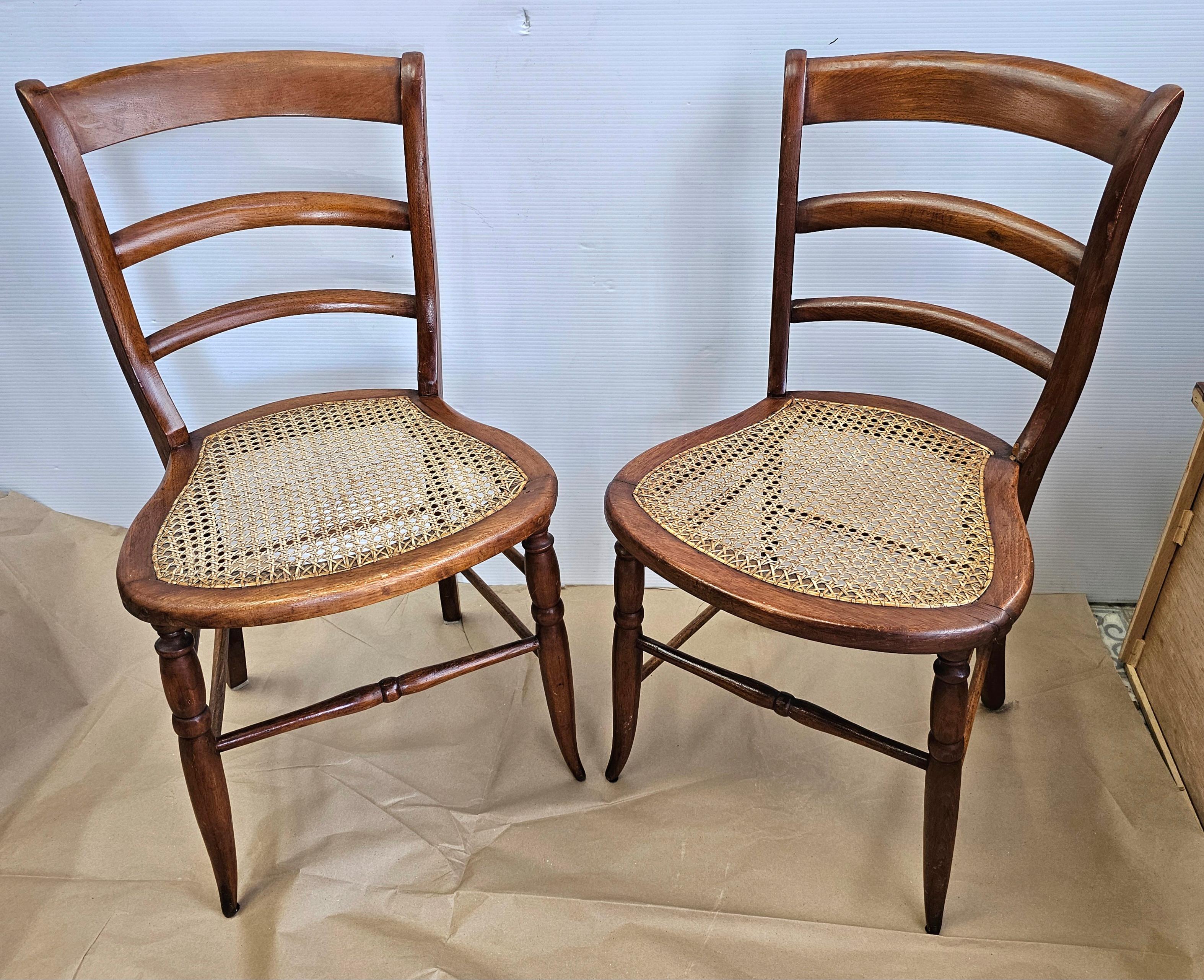Américain Paire de chaises d'appoint victoriennes de la fin du 19e siècle à dossier en échelles, en noyer et à assise en rotin en vente