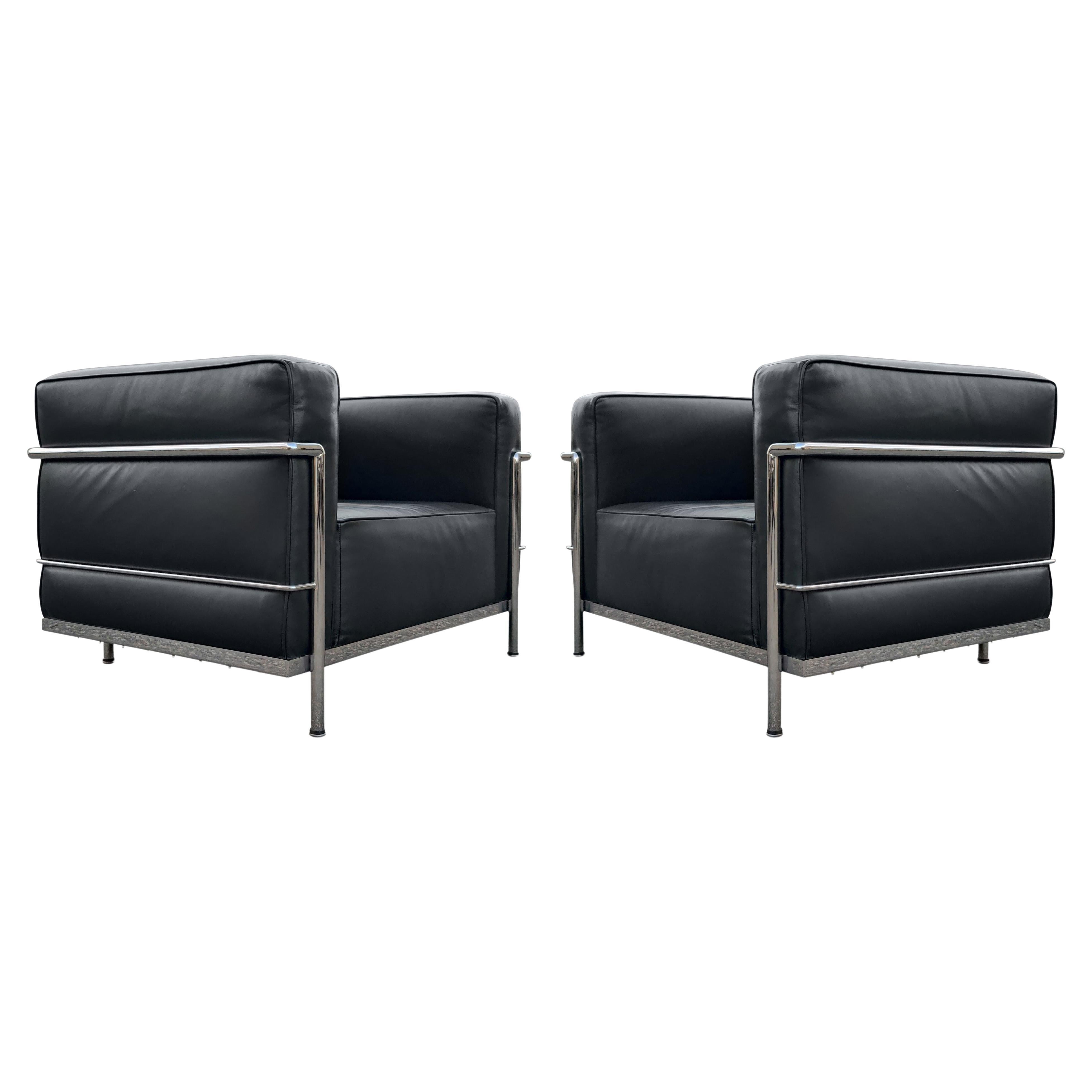 A pair of lounge or club chairs by Le Corbusier, LC8 Grand Confort, in black leather upholstery and triple chrome-plated steel frames. Each chair is signed and in like new condition! Super clean and super comfortable! LC/8: W 39 D 29 H 26.5 St Ht 14.