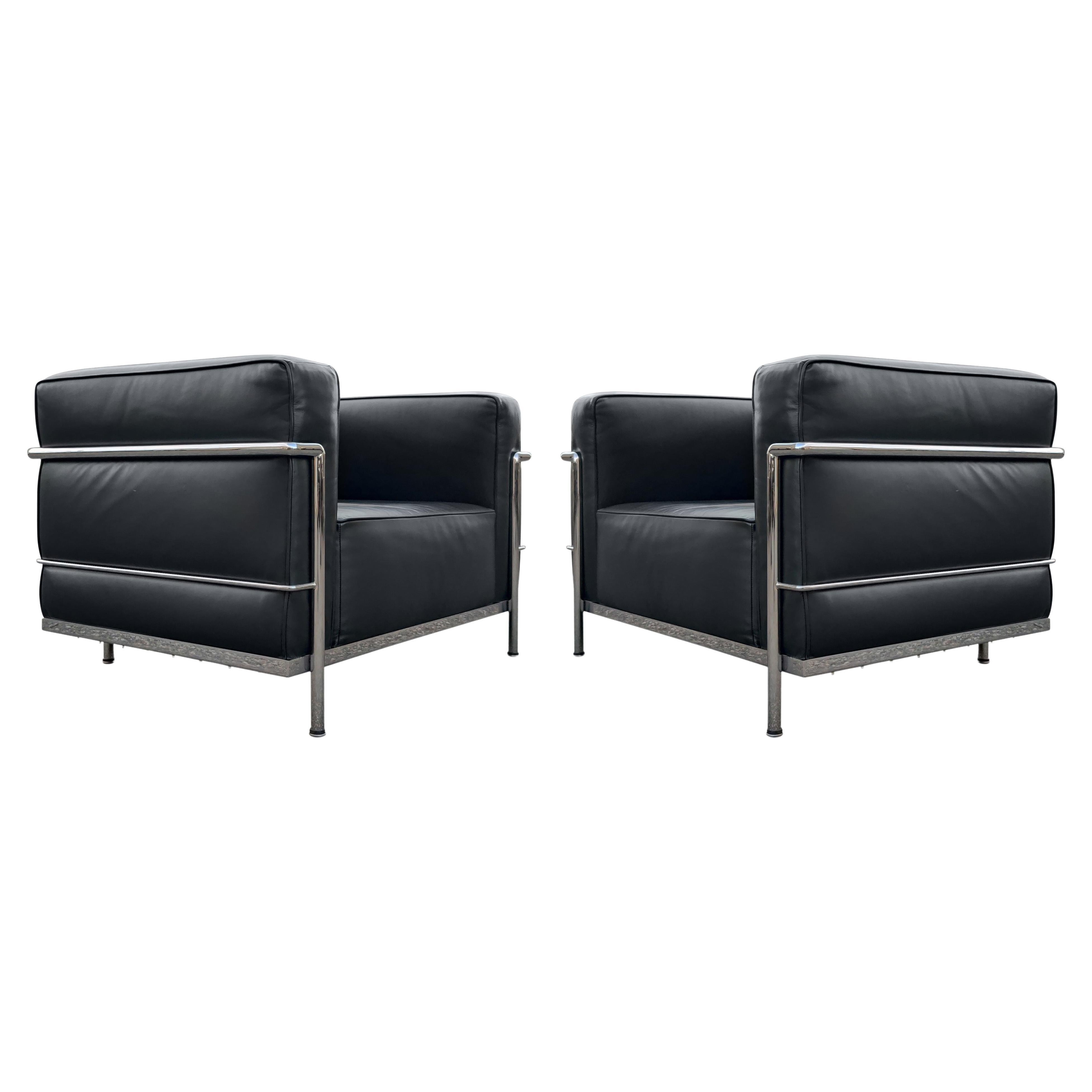 A pair of lounge or club chairs by Le Corbusier, LC8 Grand Confort, in black leather upholstery and triple chrome-plated steel frames. Each chair is signed and in like new condition! Super clean and super comfortable! LC/8: W 39 D 29 H 26.5 St Ht 14.
