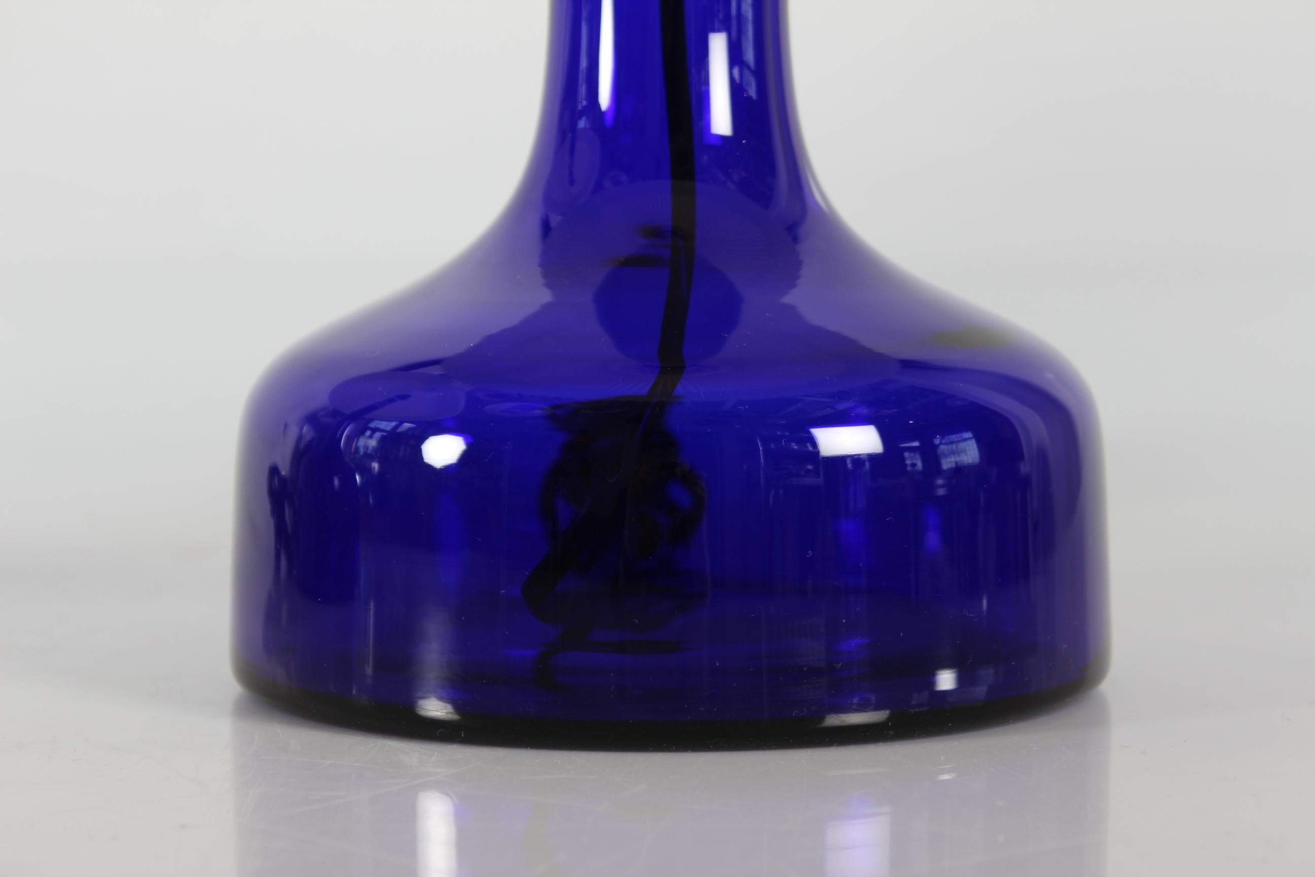 Pair of large Danish table lamp model no. 302 by danish designer by Gunnar Biilmann-Petersen 
The lamp foots are made of mouth blown translucent dark blue glass from Holmegaard glass works and comes with the original vintage Le Klint lamp