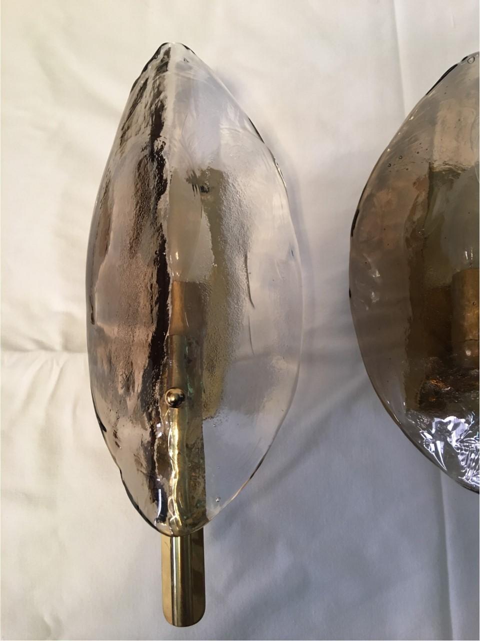 A pair beautiful Austrian J.T. Kalmar wall lights, manufactured in midcentury, circa 1970. A leaf shaped two-tone clear and smoked or amber Murano glass with a brass fixture. Marked with Kalmar label. Each fixture requires one European E14