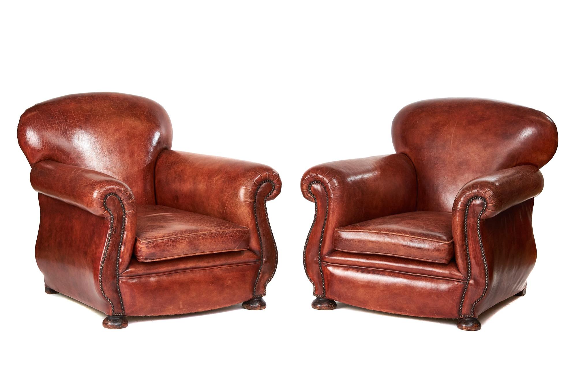 Pair leather club chairs, circa 1920s.
Recently upholstered in leather and coloured to chestnut
I have expert French Polishers, to colour and shade the leather,
good worn leather finish, 
brass studded decoration on front & back
loose