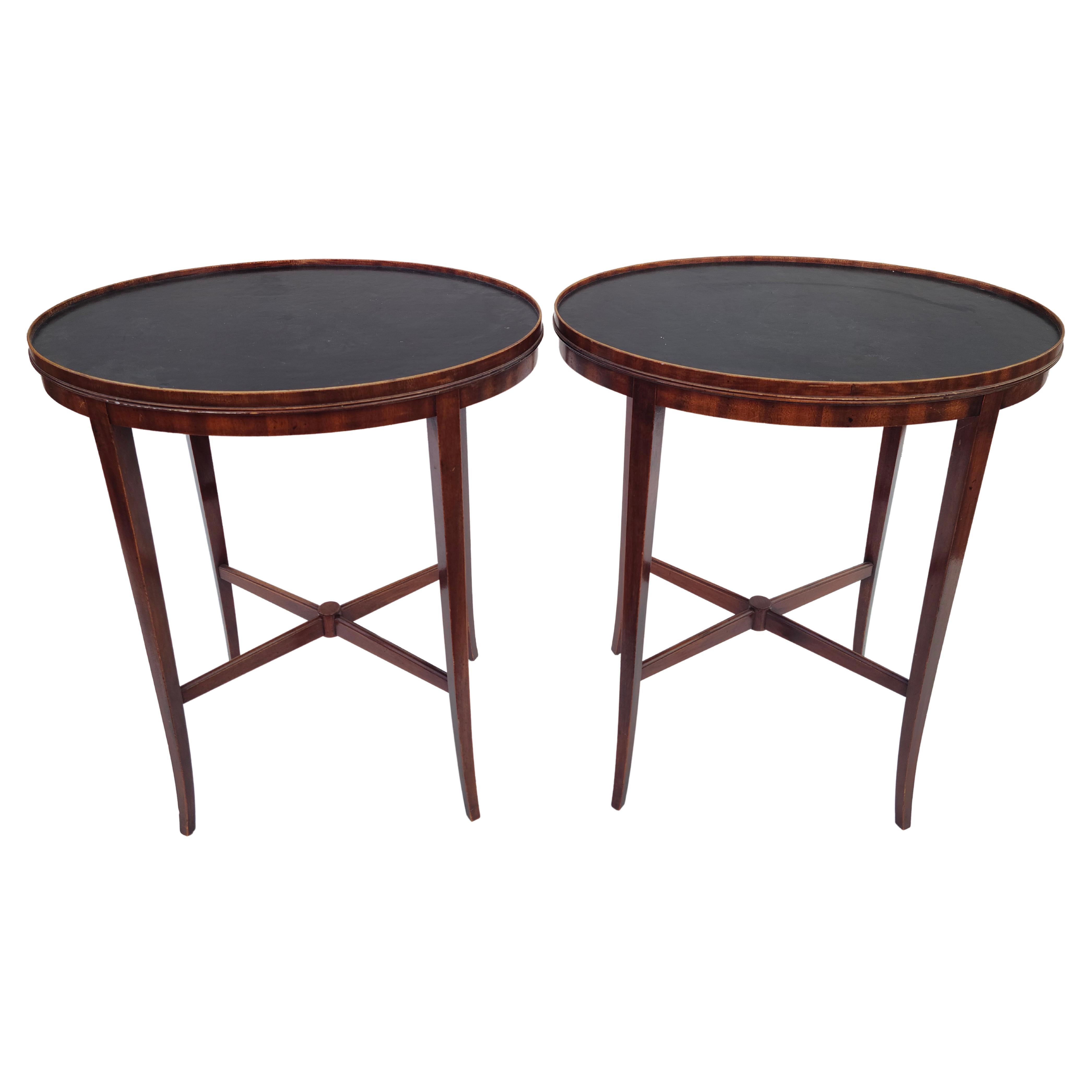 Pair saber leg oval side tables.
Black Leather top. Mahogany construction.
Seems to follow design cues similarly used by Tommi Parzinger.
Does not have Charak label. 