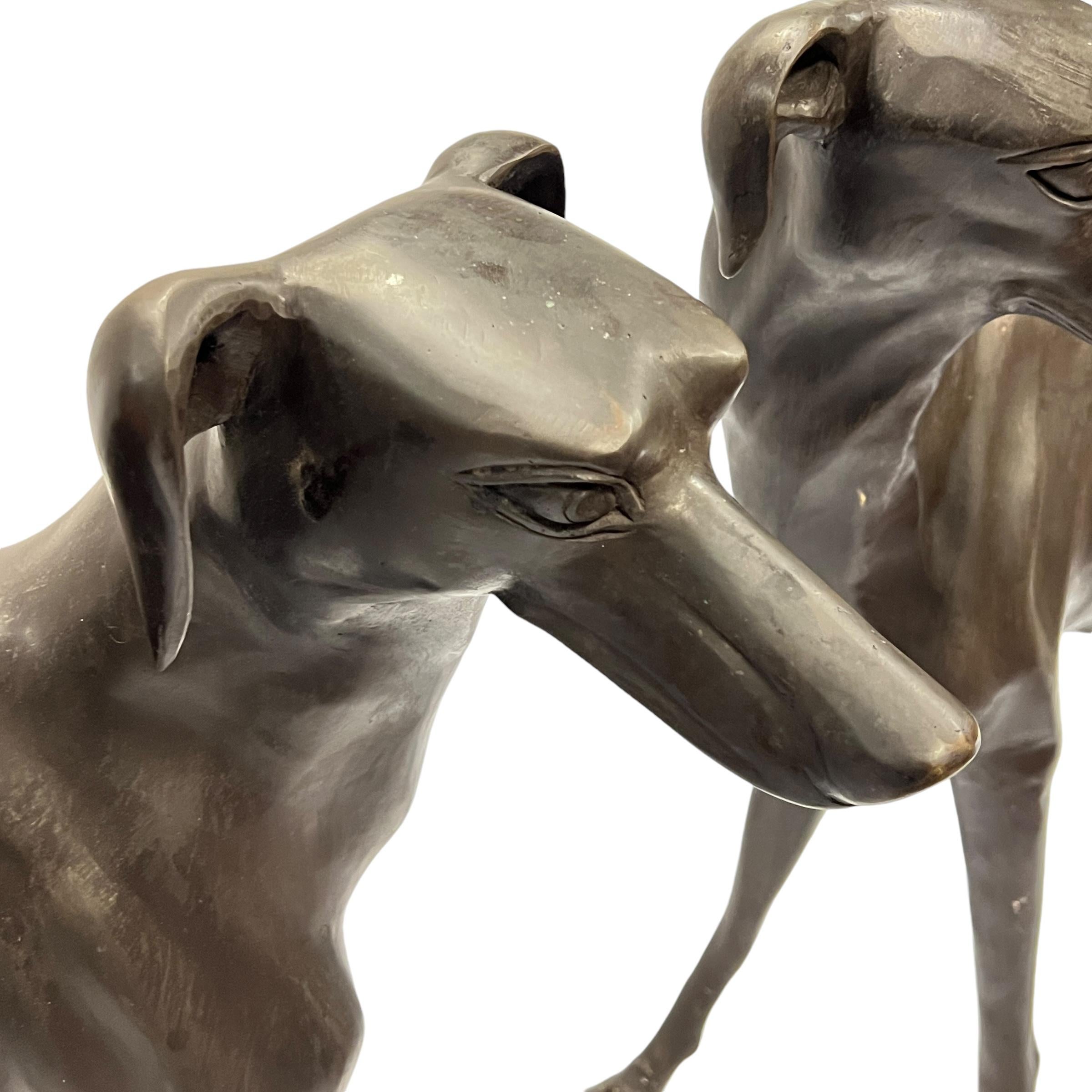 Pair of lifesize bronze hounds, each approximately 32 inches long and 32 inches tall, with dark brown patina.  Dating from the mid-century period and apparently unsigned.