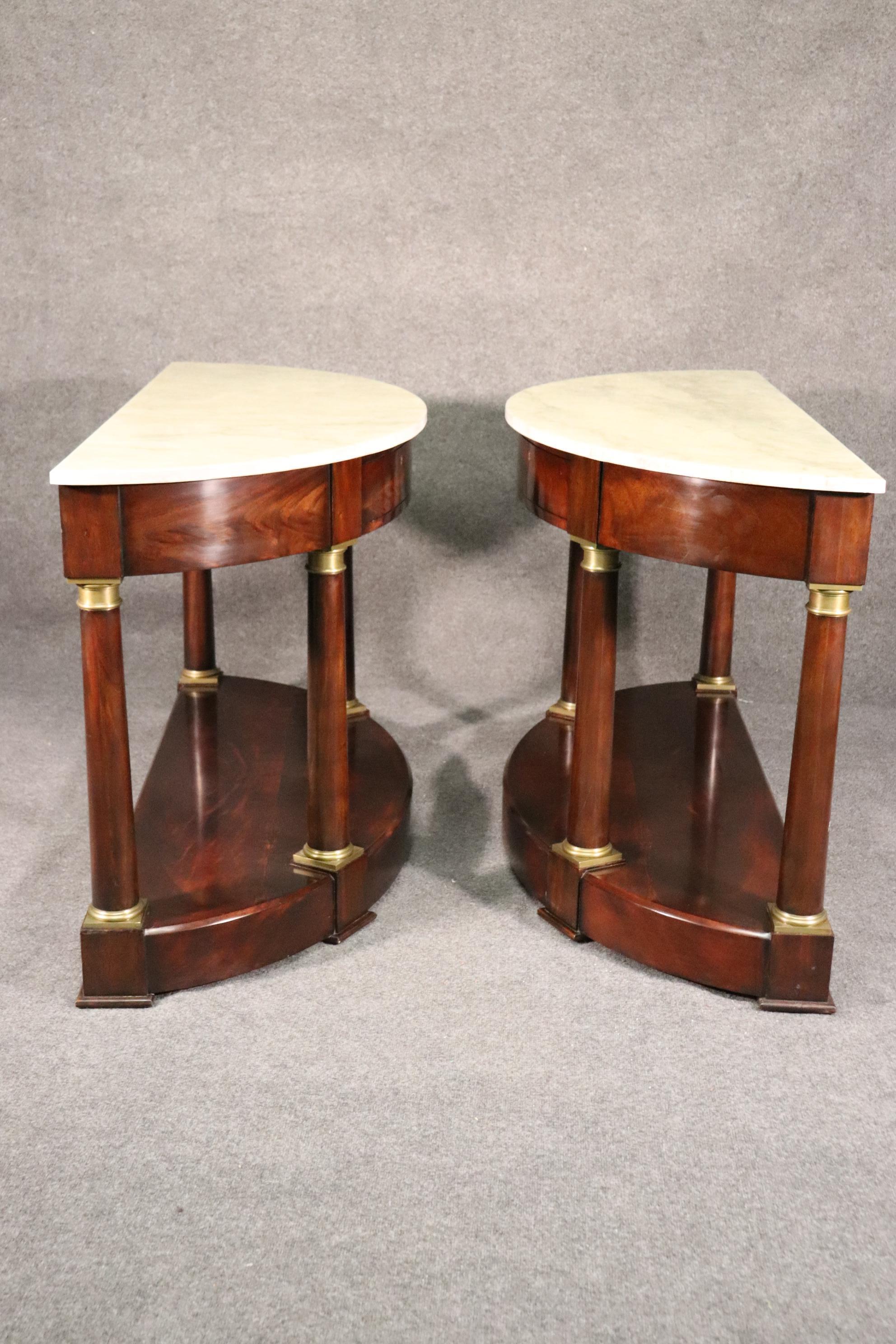 This is a gorgeous pair of Lillian August for Hickory White furniture mahogany and faux painted marble top demilune console tables. The tables are in good original condition and date to the 2000s era and are very gently used. The tables measure 56
