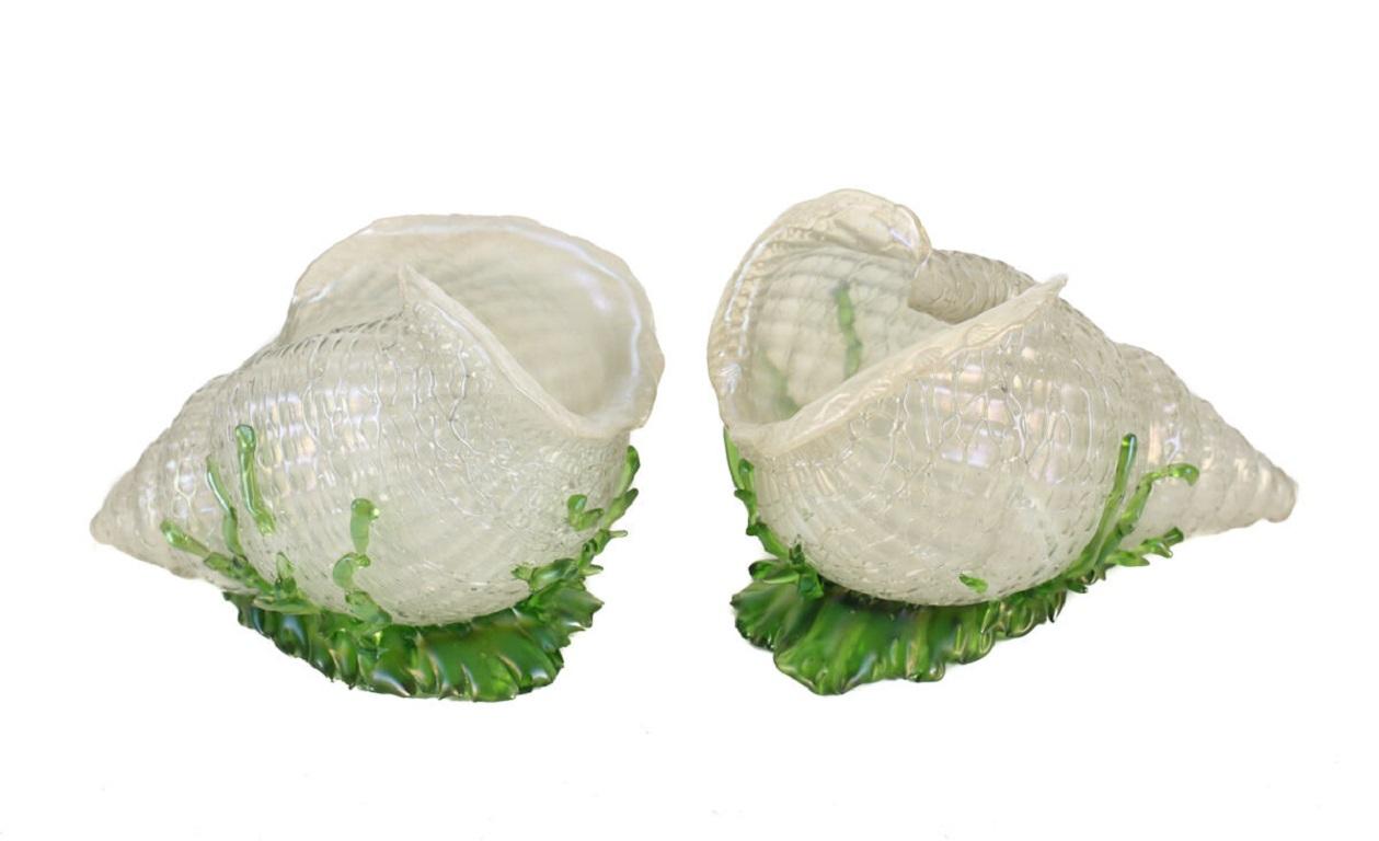 Pair Loetz Applied Threaded Green Iridescent Conch Shells Seaweed, 20th Century

A pair of iridescent art glass sculptures in the form of conch shells. Applied and threaded throughout with green and white, laying on a bed of seaweed, by Loetz from 