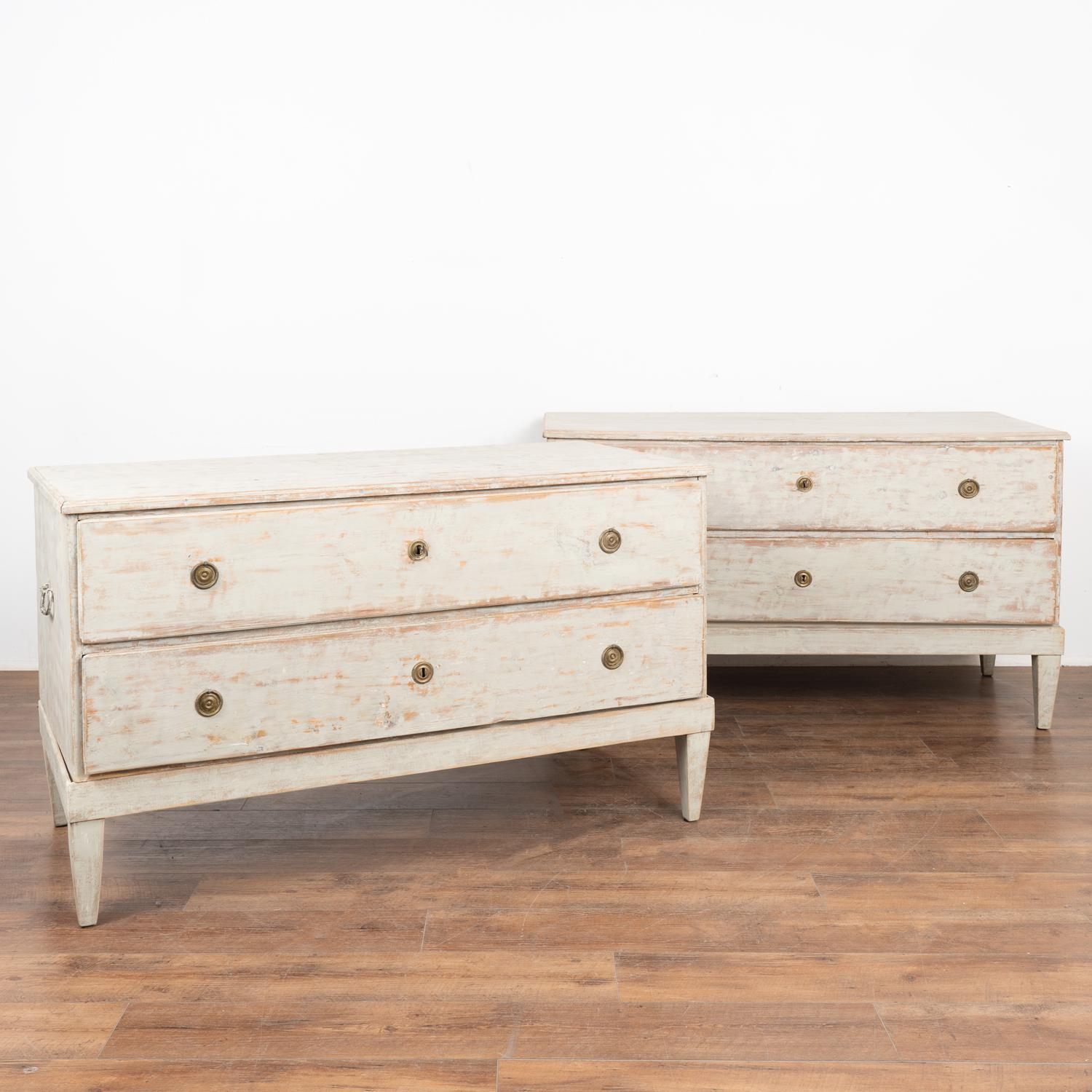 Pair, long pine chest of two drawers with newer, professionally applied light dove gray painted and distressed finish which fits the age and grace of the pair.
The unique size of 4.5' long make these chests a special find.
Two brass pulls on each