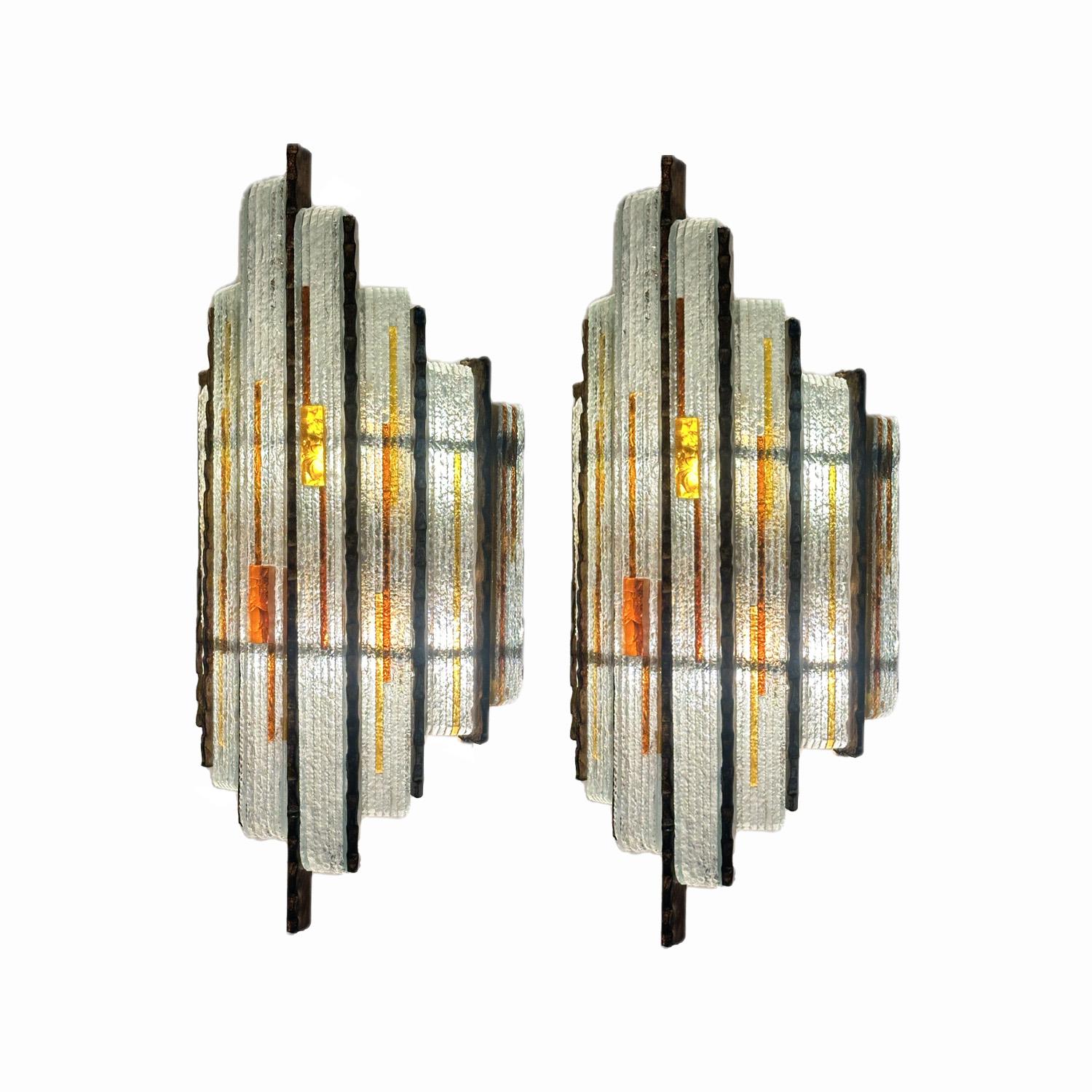 This pair of clear and Amber hammered Murano glass sconces highlight's Longobard’s guiding principle that lighting designs be visually stunning and practical, an approach that not only illuminated spaces but enhanceed their aesthetic appeal as well.