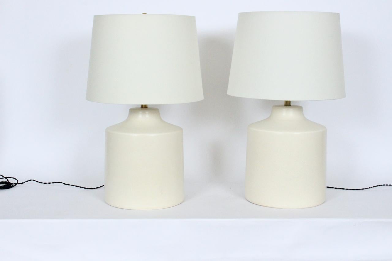 Original pair of Lotte and Gunnar Bostlund Off white Pottery table lamps, circa 1960. Featuring classic smooth matte glazed stoneware forms. 24H to top of finial. 16 H to top of socket. 12.5 H to top of Ceramic. Shades shown for display only and not