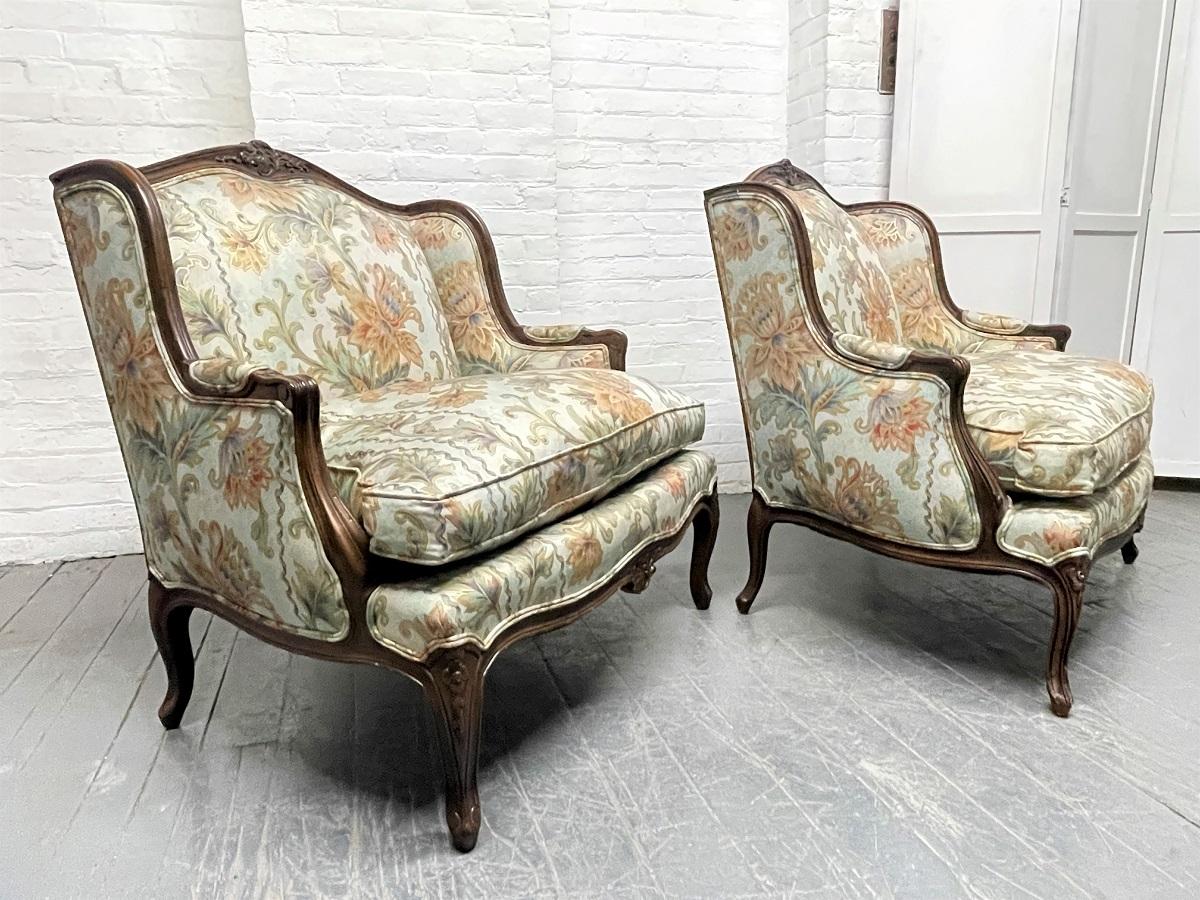 Paar Louis XIV Stühle im antiken Stil in Übergröße. Die Stühle haben den ursprünglichen geblümten Stoff mit Daunensitzen und geschnitzten Hartholzrahmen.
  