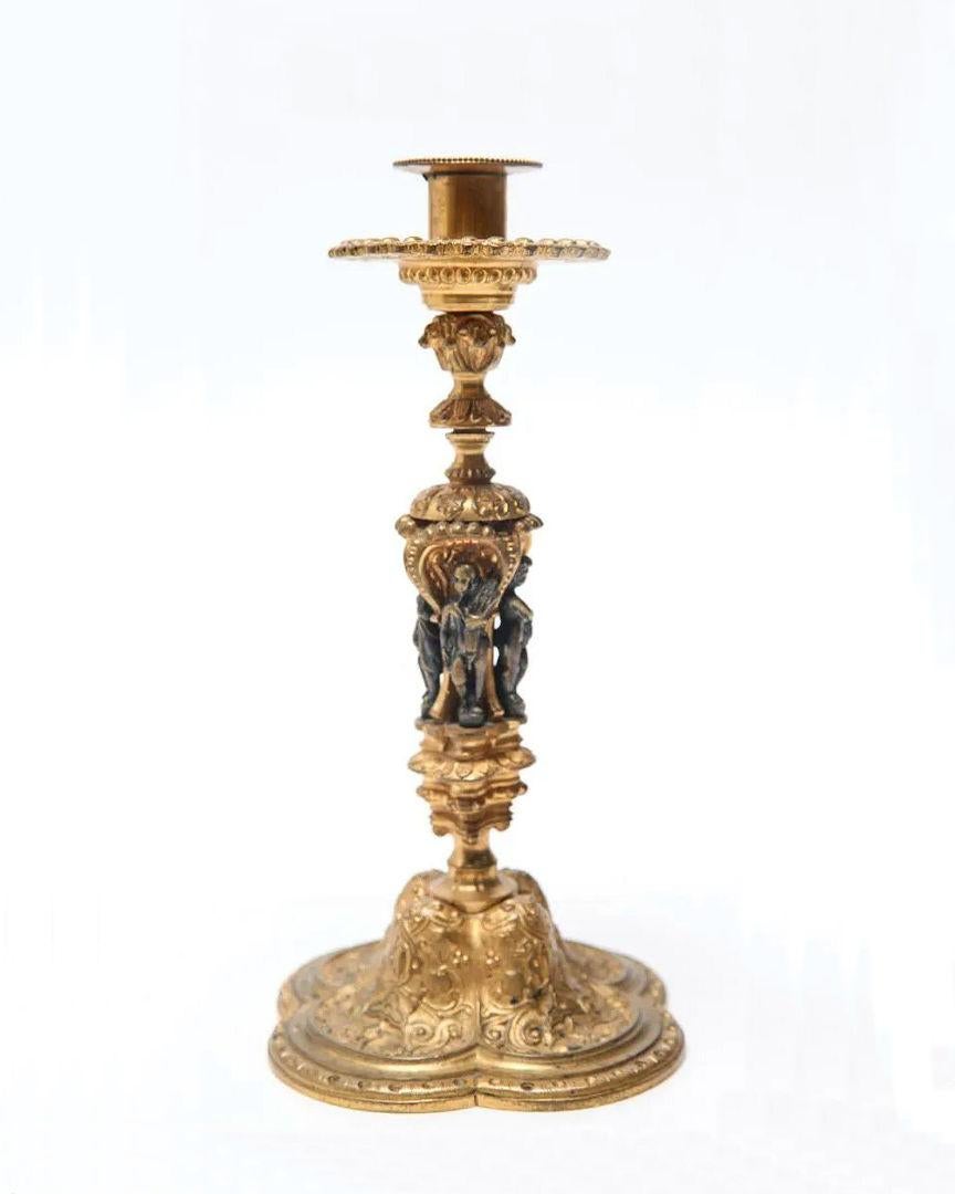 Notre paire unique de chandeliers français en bronze doré se distingue par ses minuscules figures de saints en bronze patiné et ses piédestaux en forme de quatre-feuilles.  