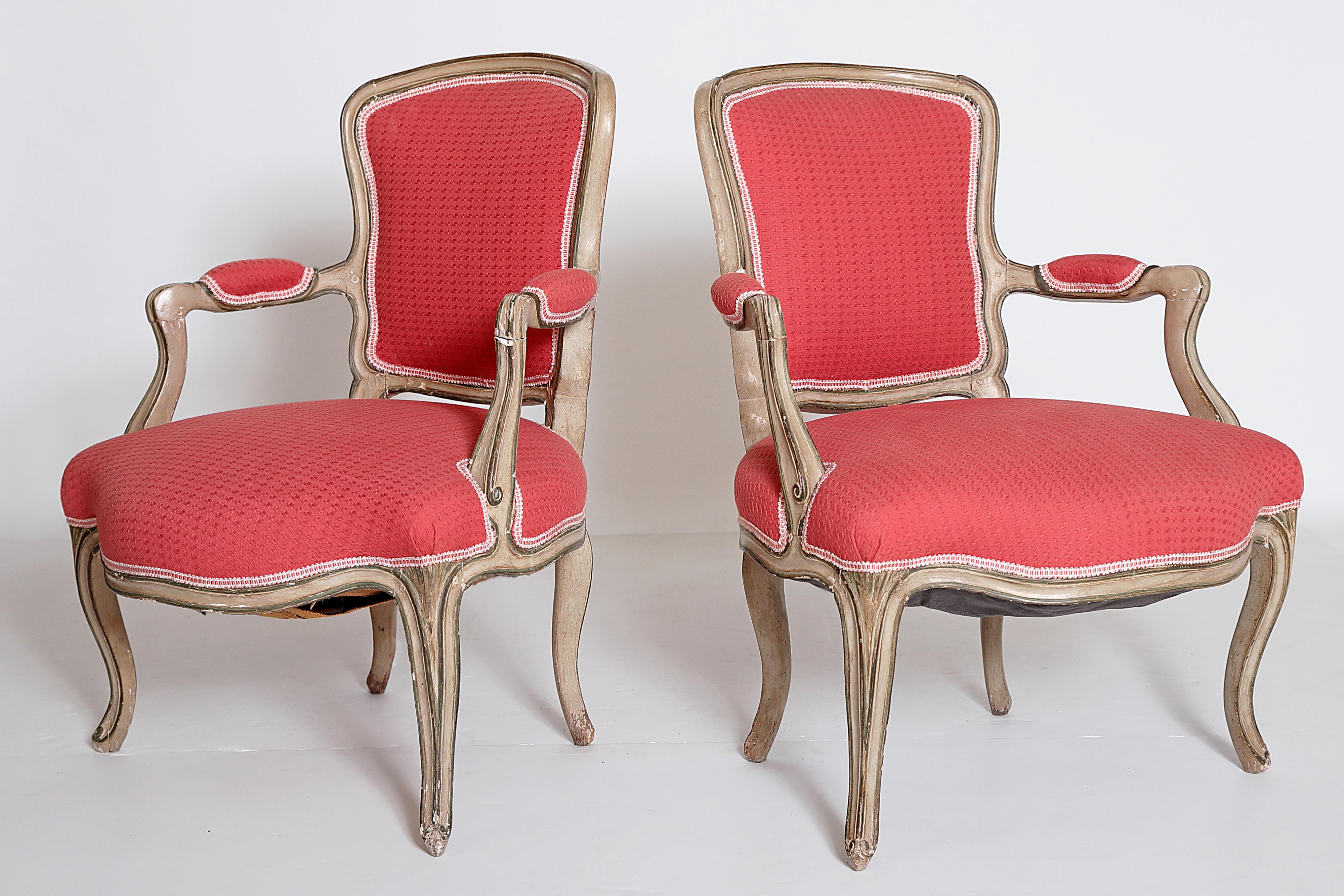 a pair of Louis XV fauteuils / open armchairs grayish-green painted frame, carved details picked out in a darker hue, textured woven coral / watermelon upholstery with lighter color trim, France, 18th century

the chairs are sprung / have springs in