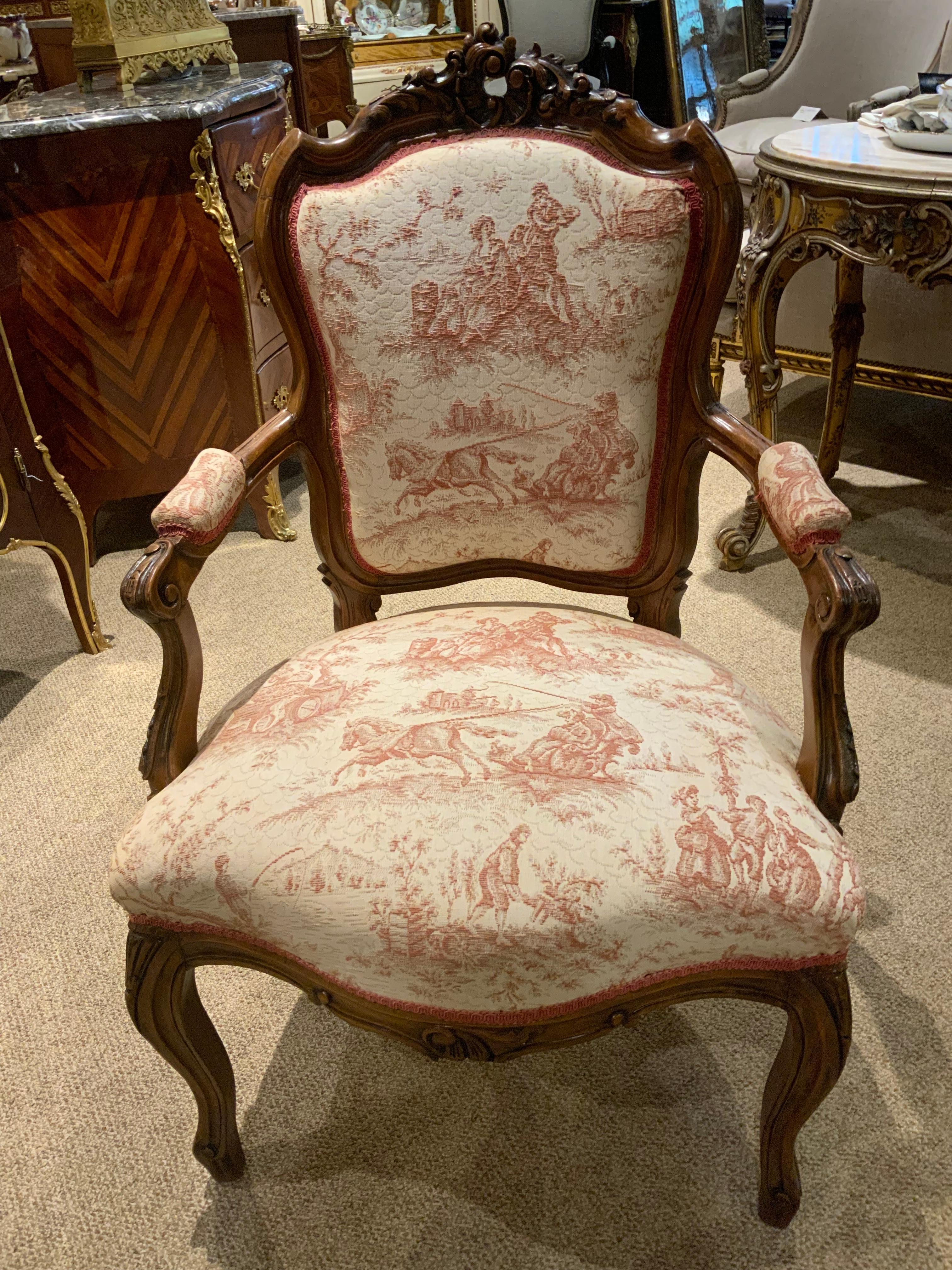 Pair of walnut framed arm chairs, beautifully carved cartouche at the crest, gracefull
Curved leg, upholstered in French toile fabric.