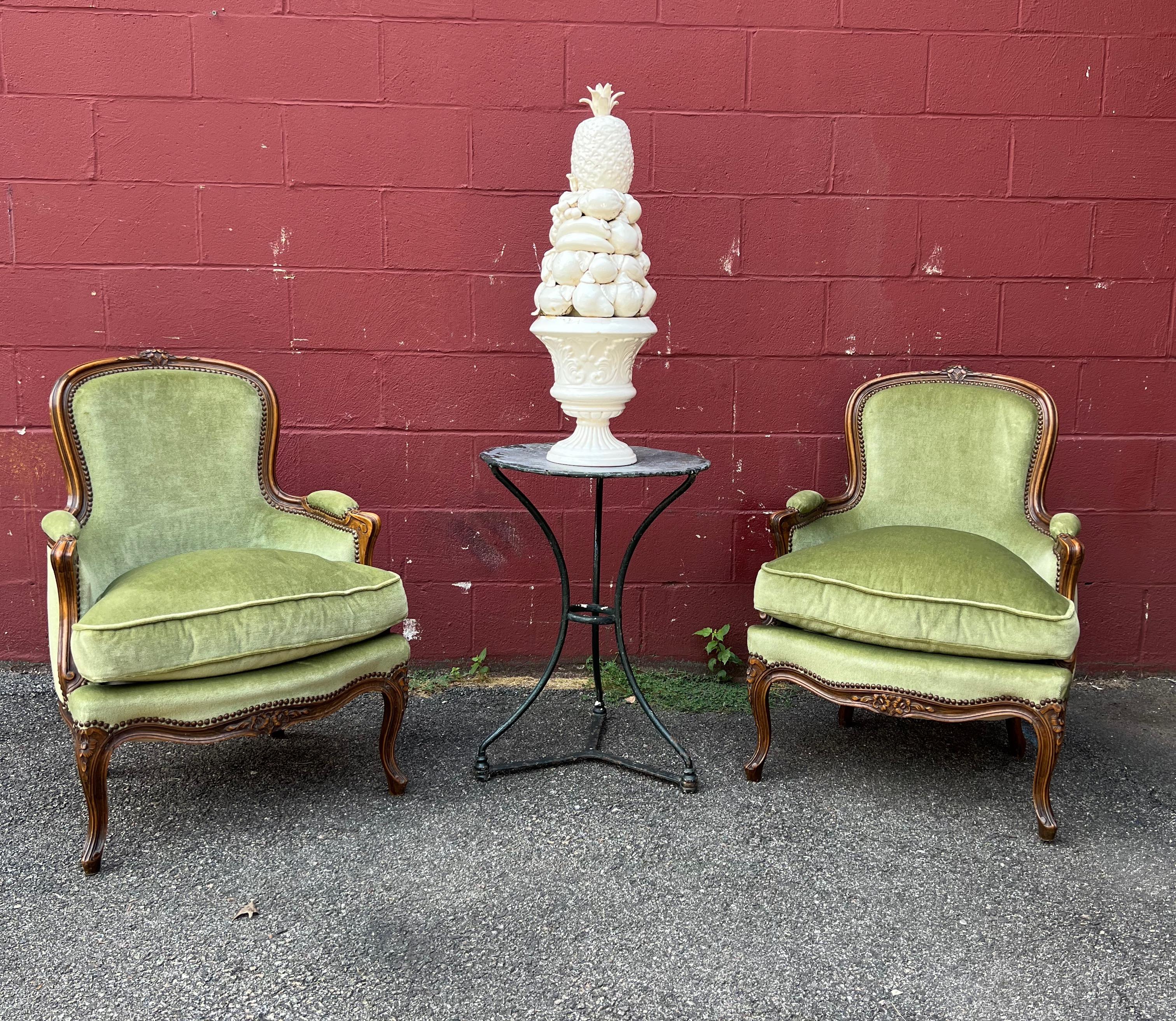 A classic pair of French Louis XV style armchairs upholstered in a rich medium green velvet. The fruitwood frames have hand carved floral motifs and graceful curved legs. Very good vintage condition.
French, circa 1920s.

Dimensions: 34” Back