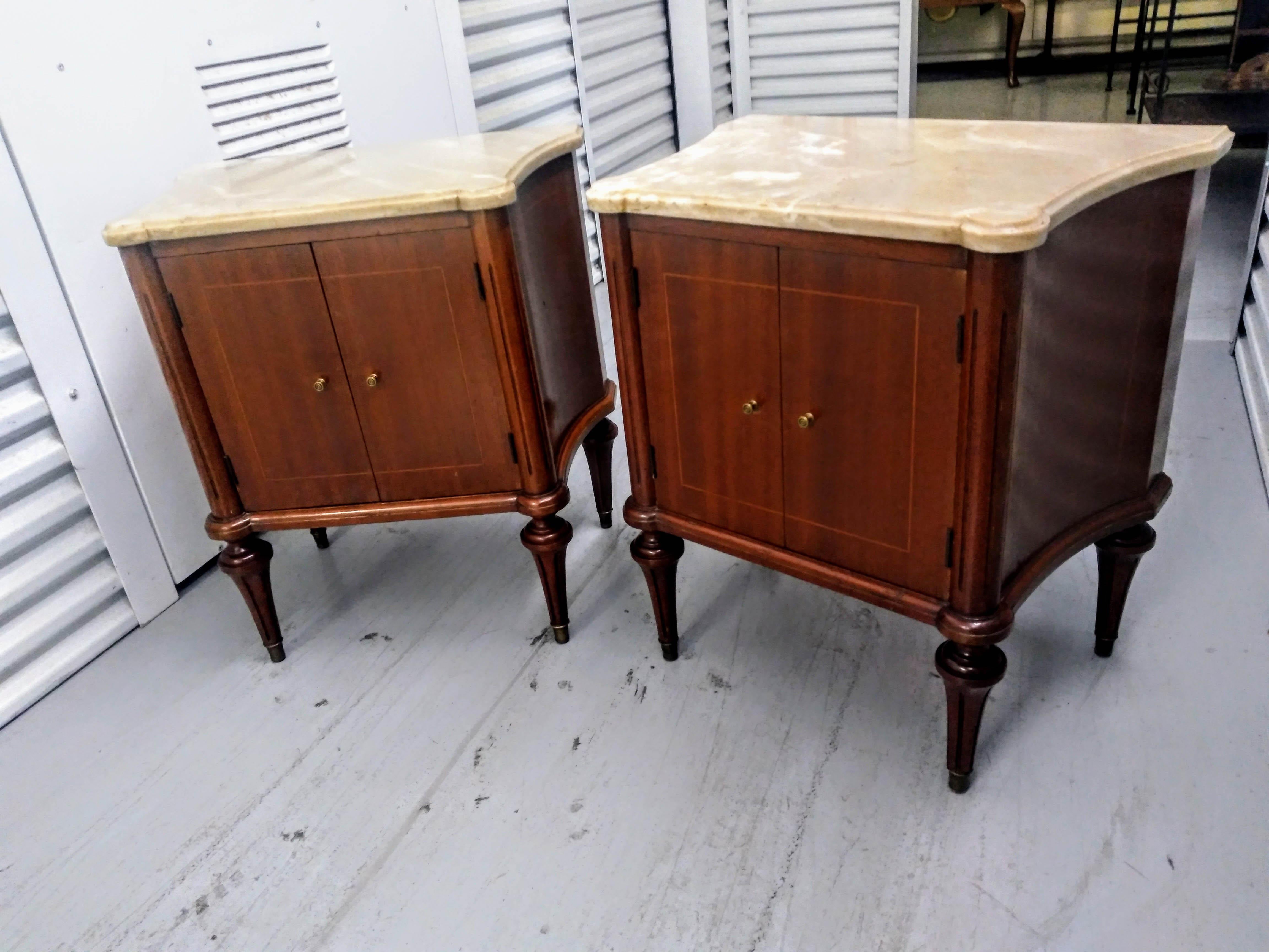 Pair Louis XVI Directoire style marble top commode nightstands

Elegant nightstands from Spain in ribbon mahogany on four tapered legs. Featuring double doors with a single drawer. The night stands have capped feet on all four legs and bronze