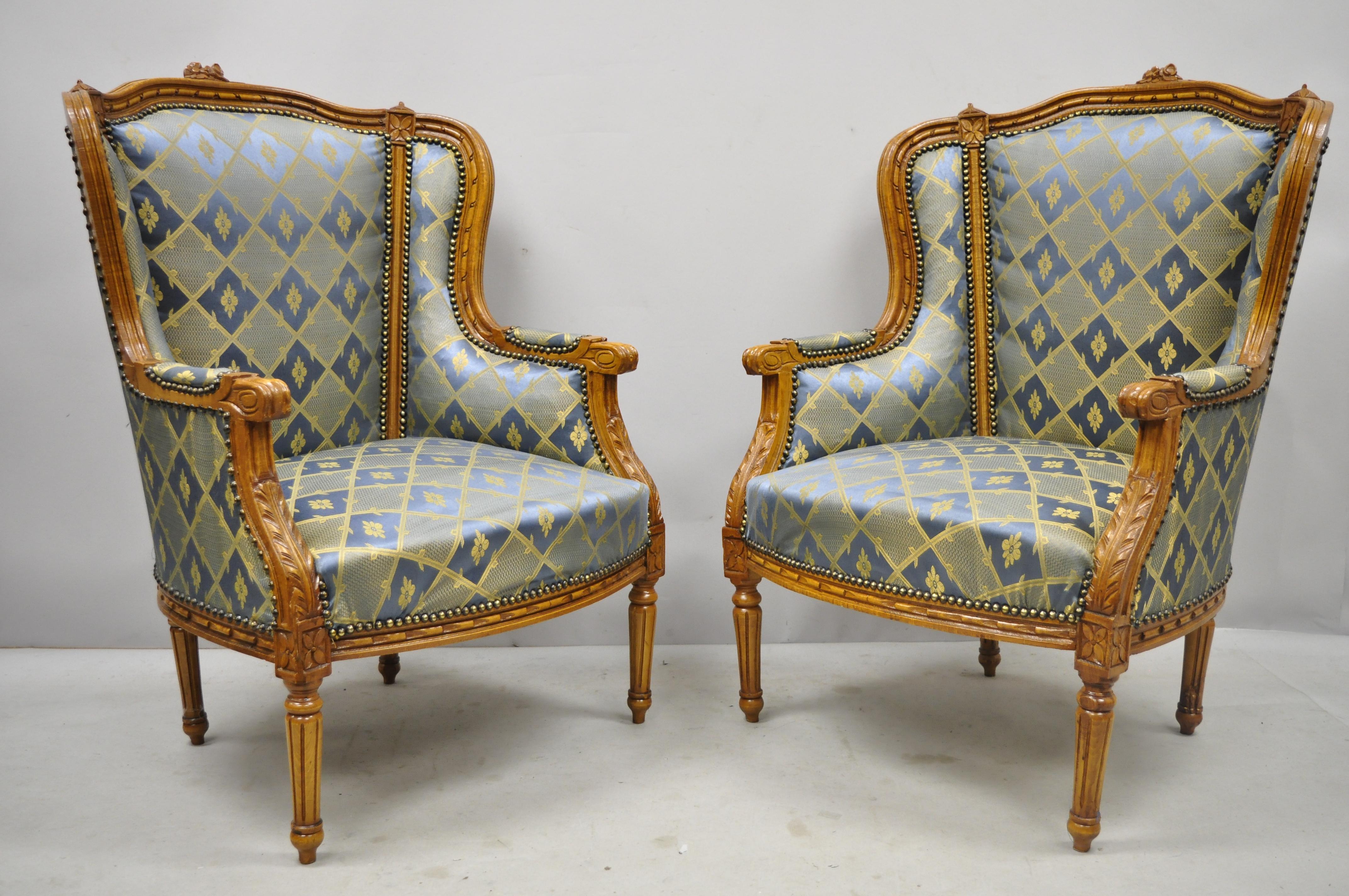 Pair of Louis XVI French style upholstered wingback bergere lounge armchairs blue gold. Listing includes a solid wood frame, upholstered armrests, nicely carved details, cabriole legs, great style and form, circa late 20th century. Measurements: