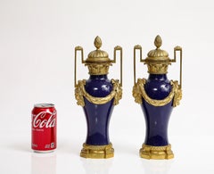 Paire de vases Louis XVI en porcelaine bleu poudré montés sur bronze doré avec masques et guirlandes