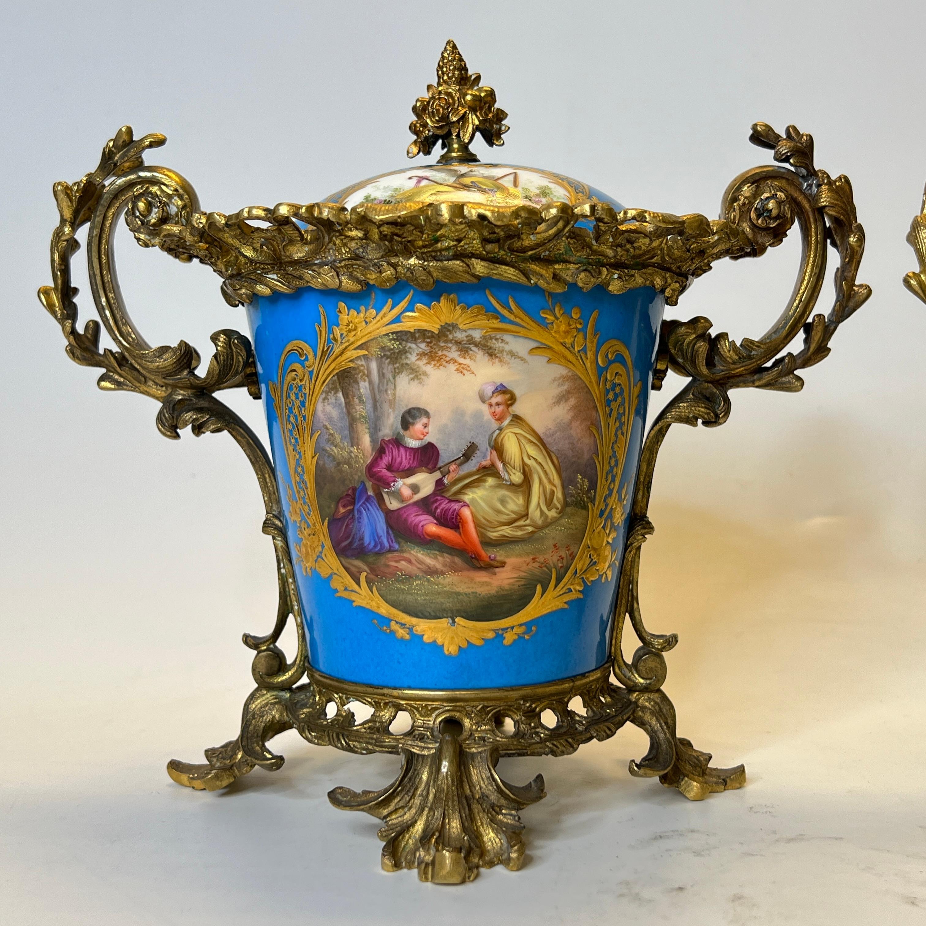 Pair Louis XVI style Celest blue hand painted Sevres Style Bronze Mounted Porcelain covered Cachepots.
with painted Vateau scenes on the front side and fruits on the back.