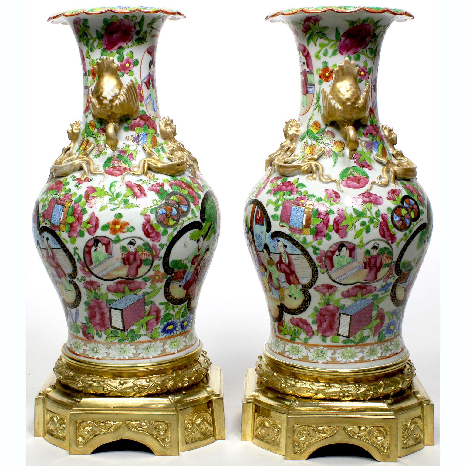 A fine pair of Louis XVI style chinoiserie gilt-bronze mounted Chinese export famille rose porcelain vases. The ovoid hand painted porcelain body with dual scenes of a sword presentation to the Royal Court, with stylized gilt dragon porcelain mounts