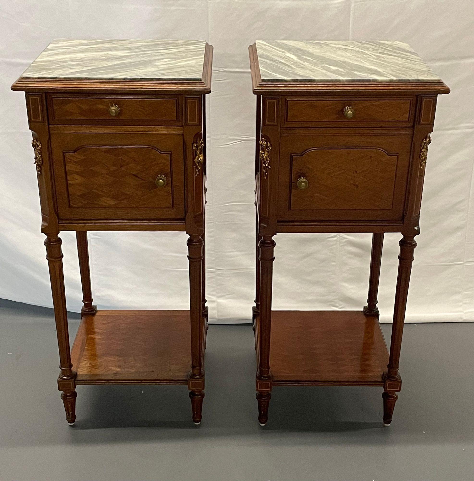 Pair Louis XVI Style End, Bedside Tables, Humidor Interiors, Parquetry Inlaid, Circa 1910
 
A lovely pair of Louis XVI Style marble top end or bedside tables. Each one opens to a marble lined interior cabinet, perhaps intended for humidor use.  The