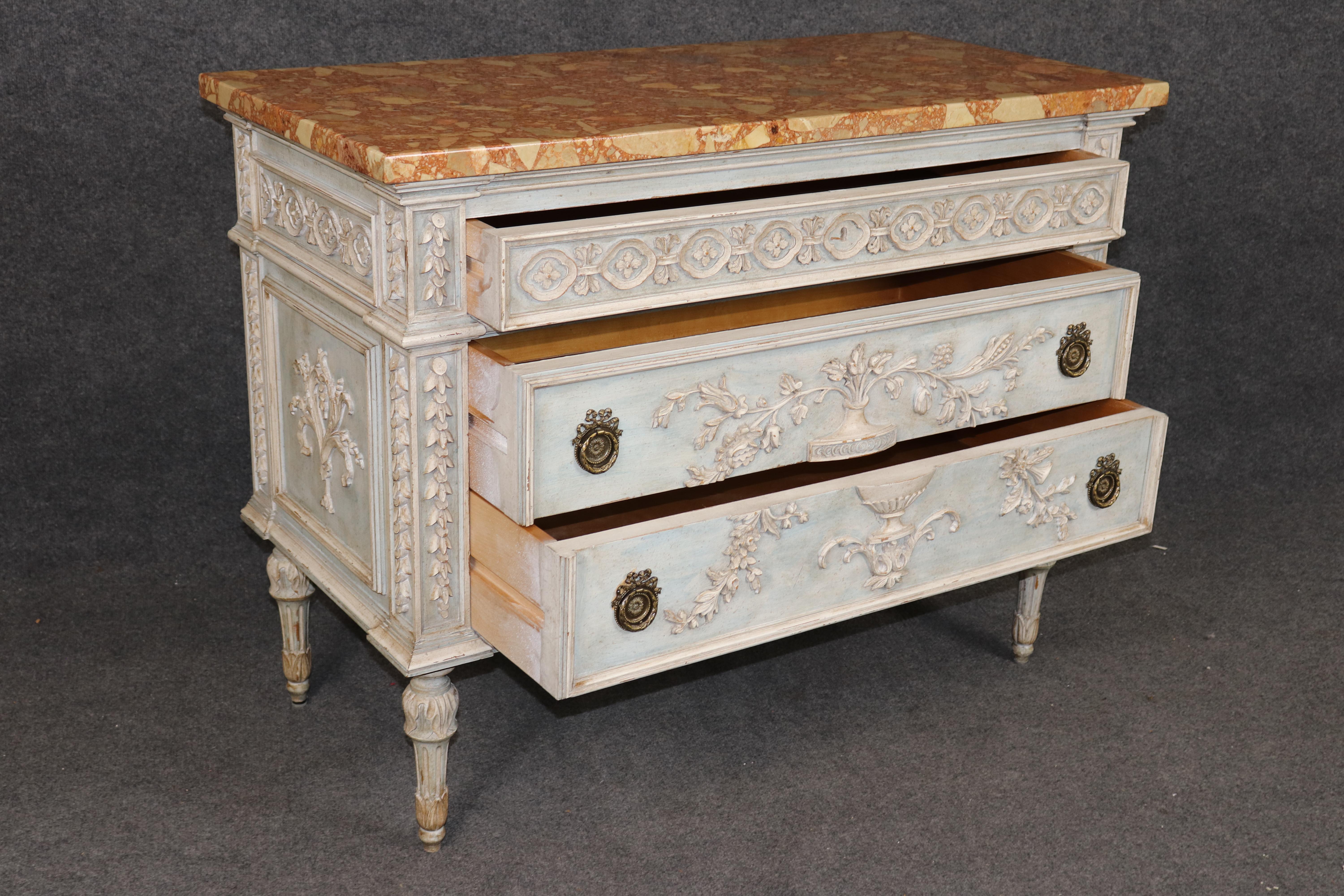 This exquisite pair of French Louis XVI style commodes from the 1930s epitomizes neoclassical refinement, combining superb craftsmanship with timeless elegance. Each commode is paint decorated in a soft antique cream with subtle patination,