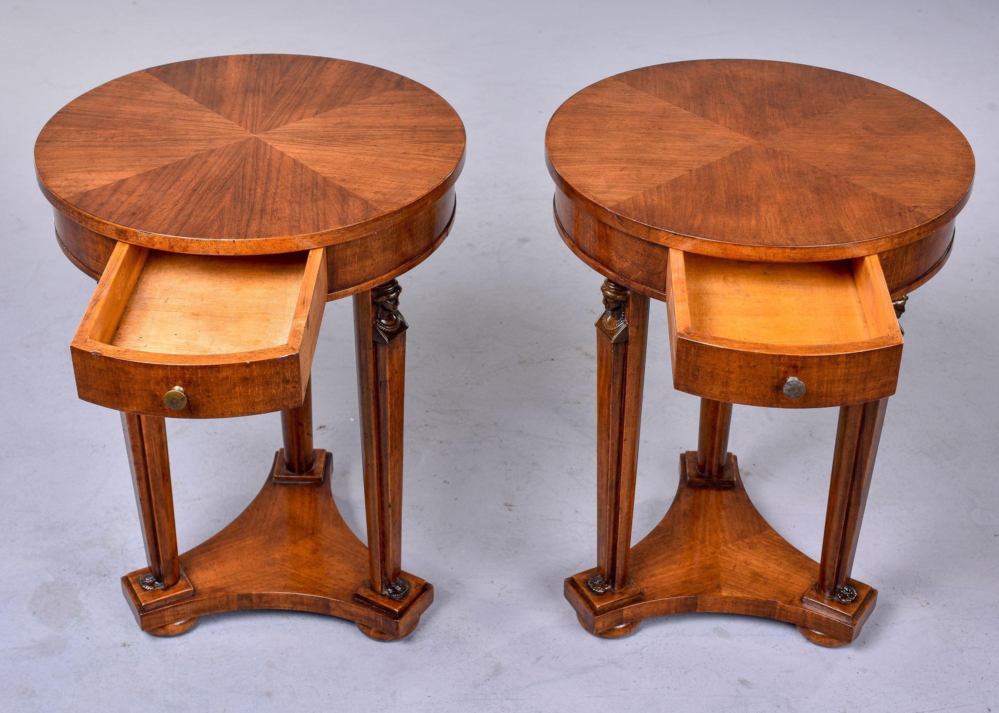 Pair Louis XVI Style round mahogany side tables
 
Found in France, this pair of Louis XVI style side tables date from approximately 1900. Each of these round tables has a decorative veneer pattern on top, small functional drawer and carved,