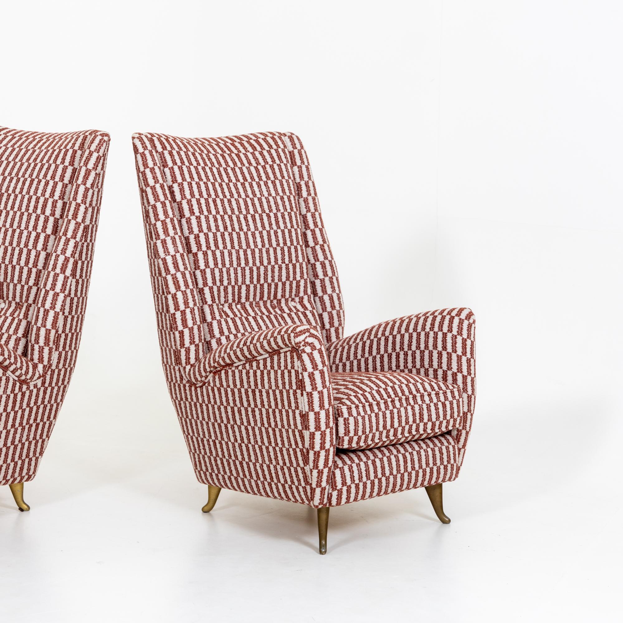 Pair of high back lounge chairs designed by Gio Ponti and produced by ISA Bergamo.
This pair of newly upholstered chairs are supported by four solid brass metal curved feet.


