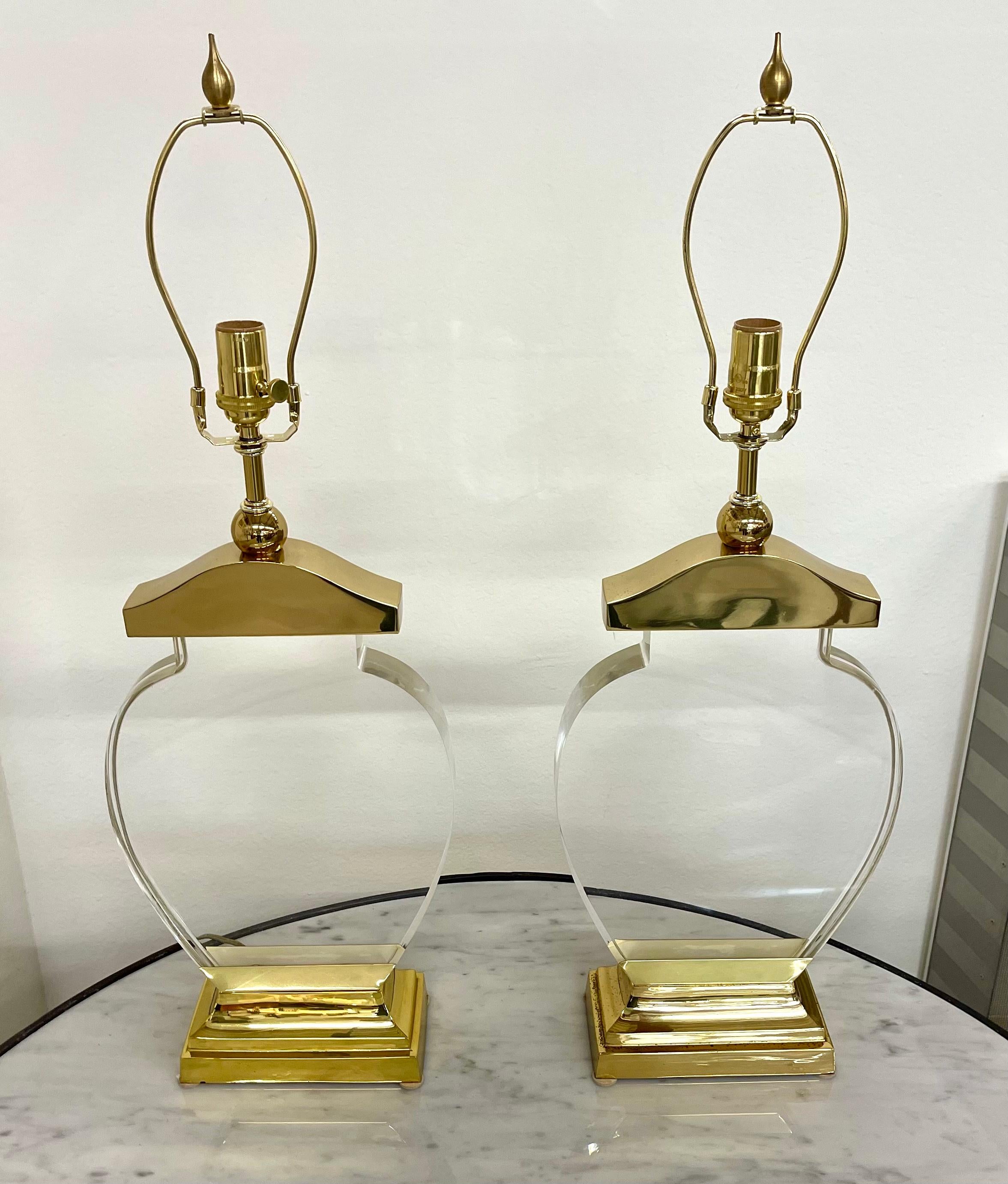 A pretty pair of vintage acrylic and brass lamps. THey have been re-wired and the hardware is new. Acrylic is in good condition. One brass base has marks to it, pictured. Lamps are 28 1/2 inches tall to finial top.They are 10 inches wide and 4 1/2