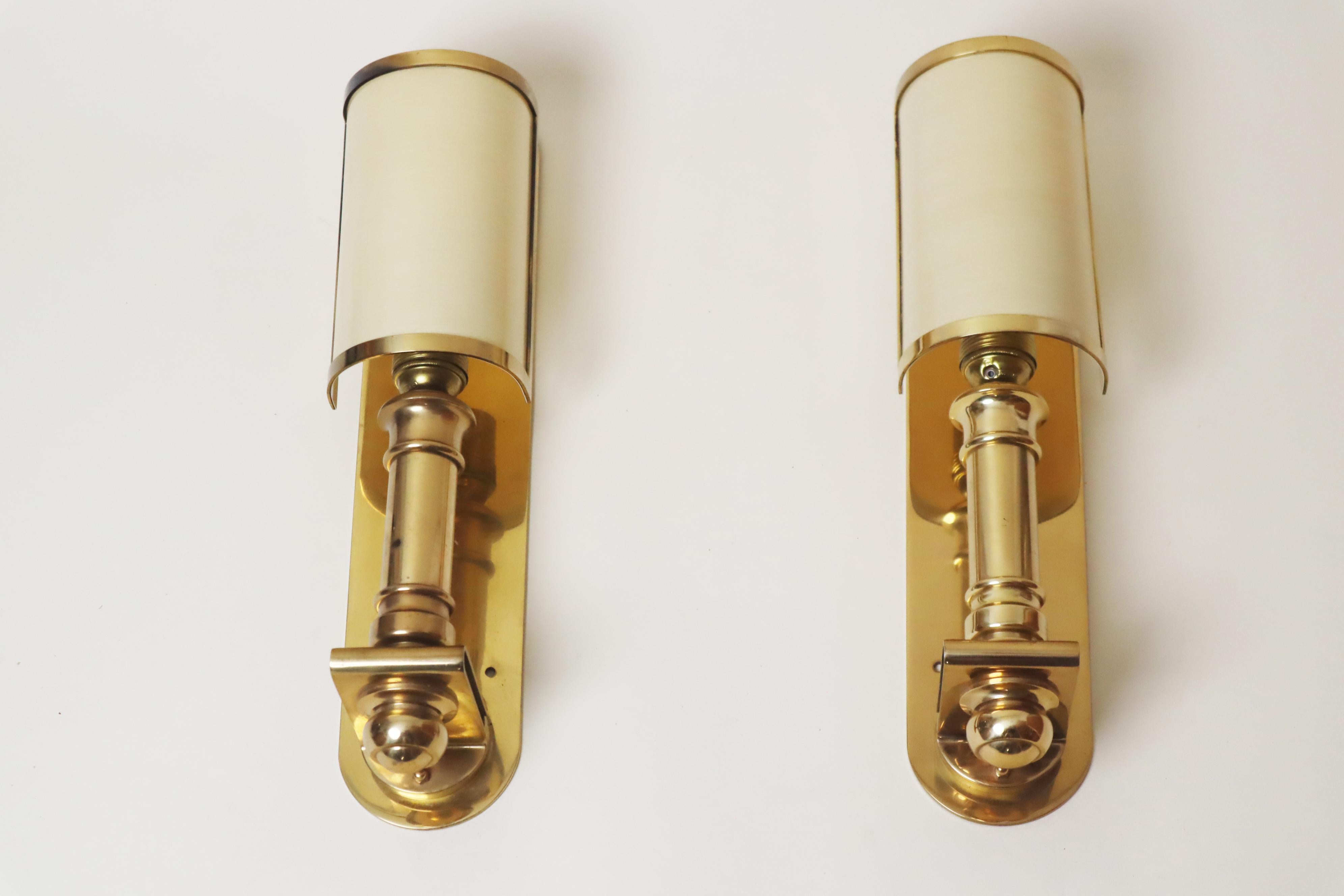 Cette paire de lampes de luxe en laiton massif se distingue par sa qualité et son savoir-faire. Le laiton est lourd et poli, et même l'abat-jour qui se fixe au pied de la lampe est doté d'un cadre en laiton de haute qualité. L'abat-jour de couleur