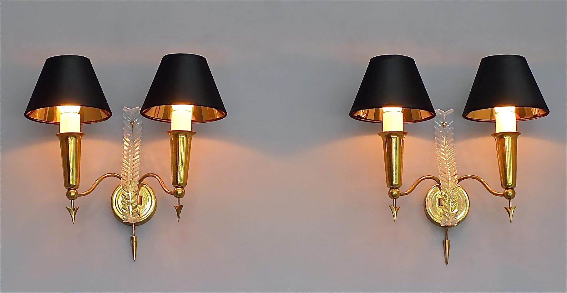 Very elegant pair of Maison Arlus midcentury sconces, Maison Jansen style, France, circa 1950s. The beautiful two-arm sconces with arrow motif inspired by Gio Pontis candelabras for Christofle are made of brass with a nice and warm patina, a