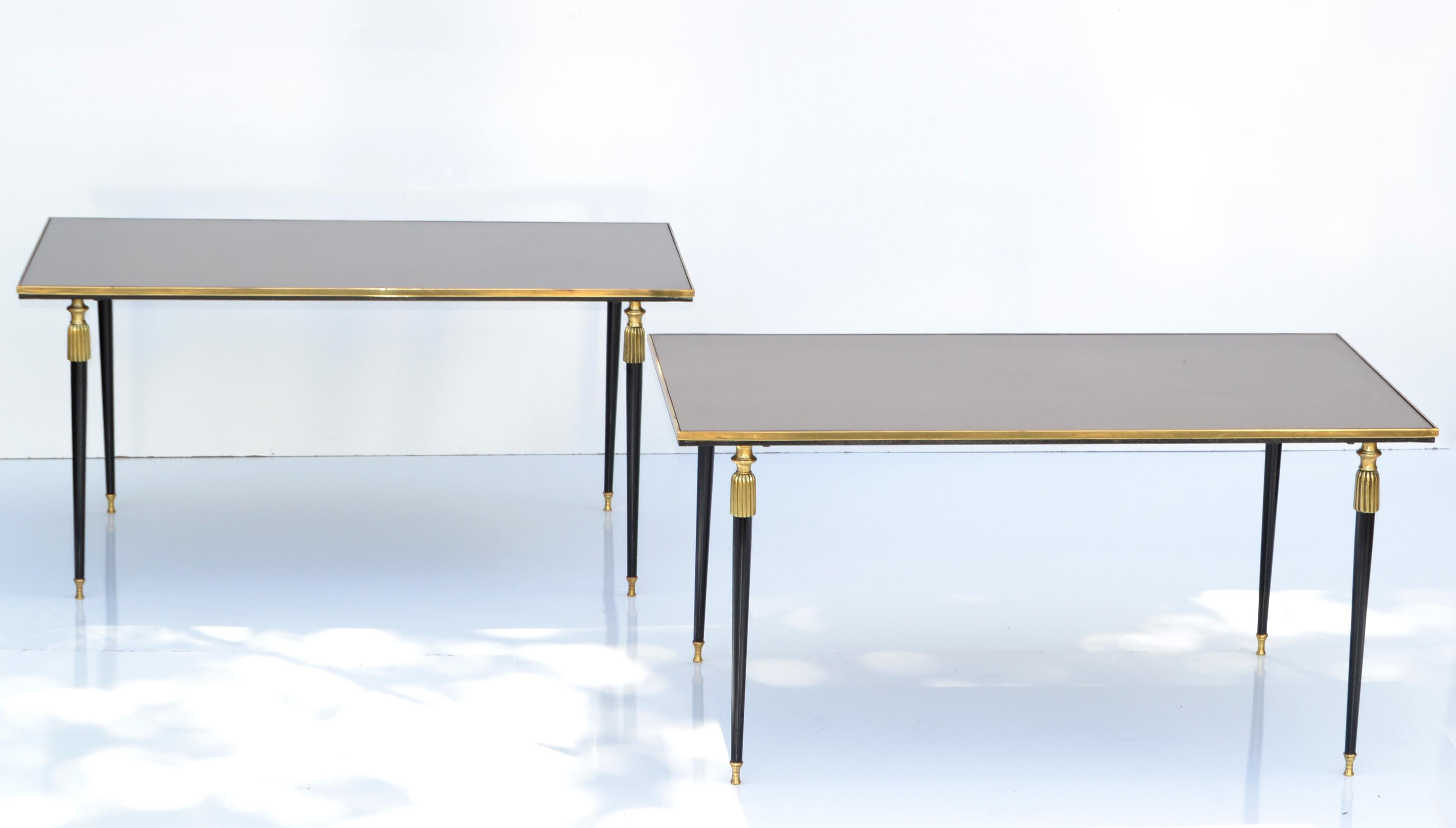 Very elegant pair of bronze and mirrored glass top side tables by Maison Baguès. 
Neoclassical Design made in Paris France circa 1955. 
Raised on four black lacquered tapered legs decorated with brass sabots. 
Priced by Pair.